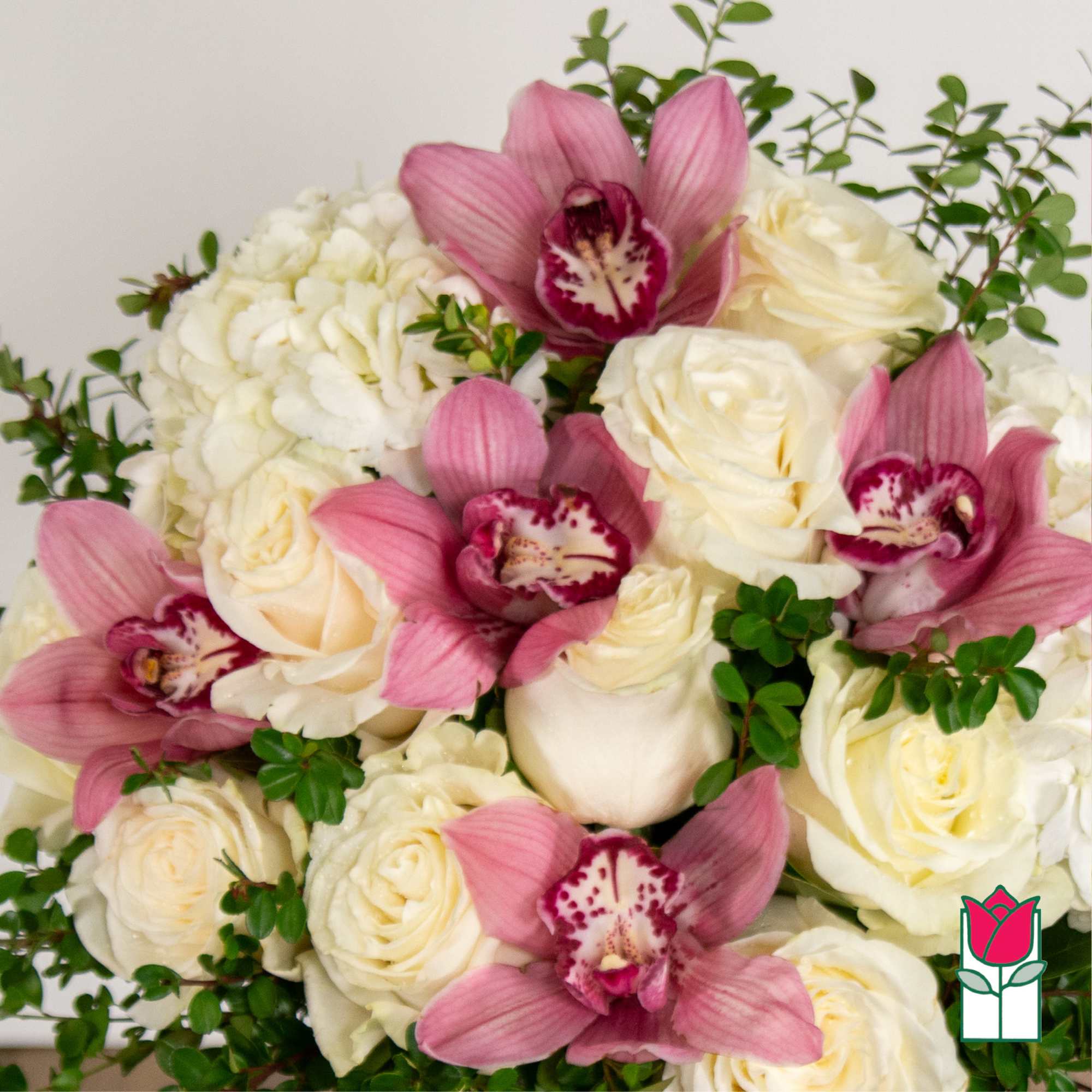 Bouquet of white roses and pink orchids with green accents