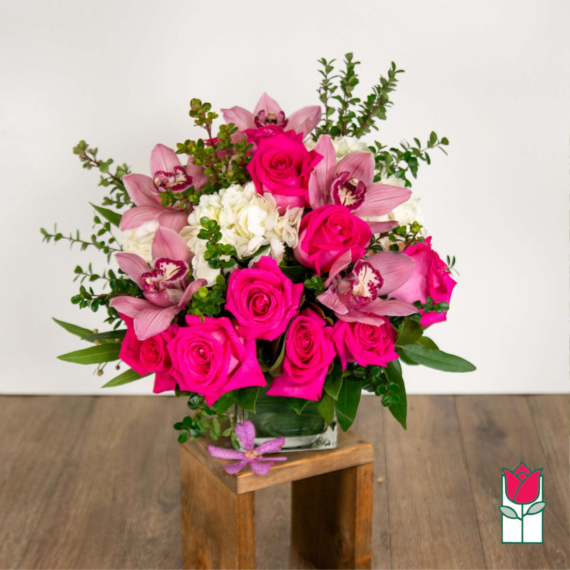 Pink roses and orchids arranged in a glass vase