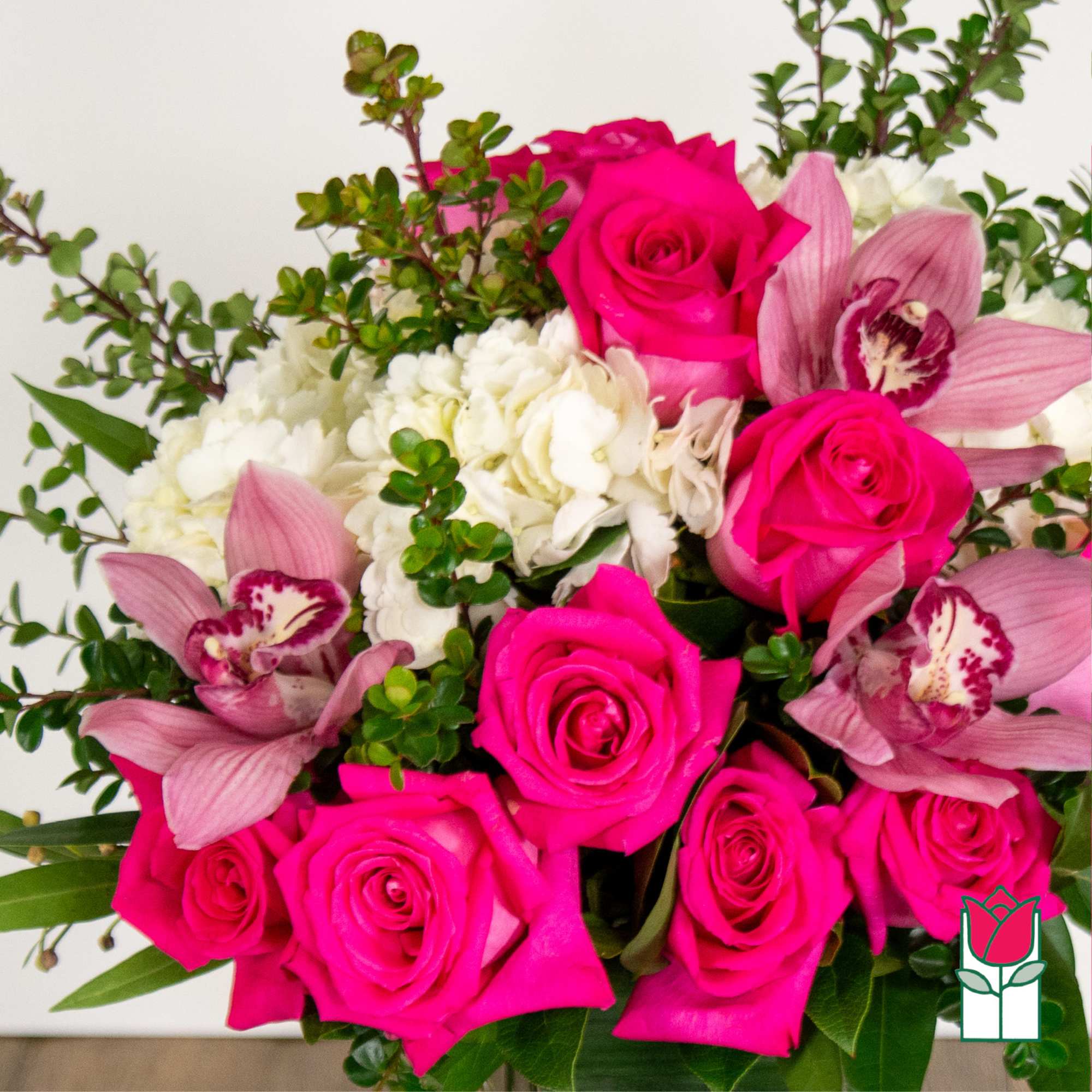 Bouquet of hot pink roses and pink orchids with white blooms