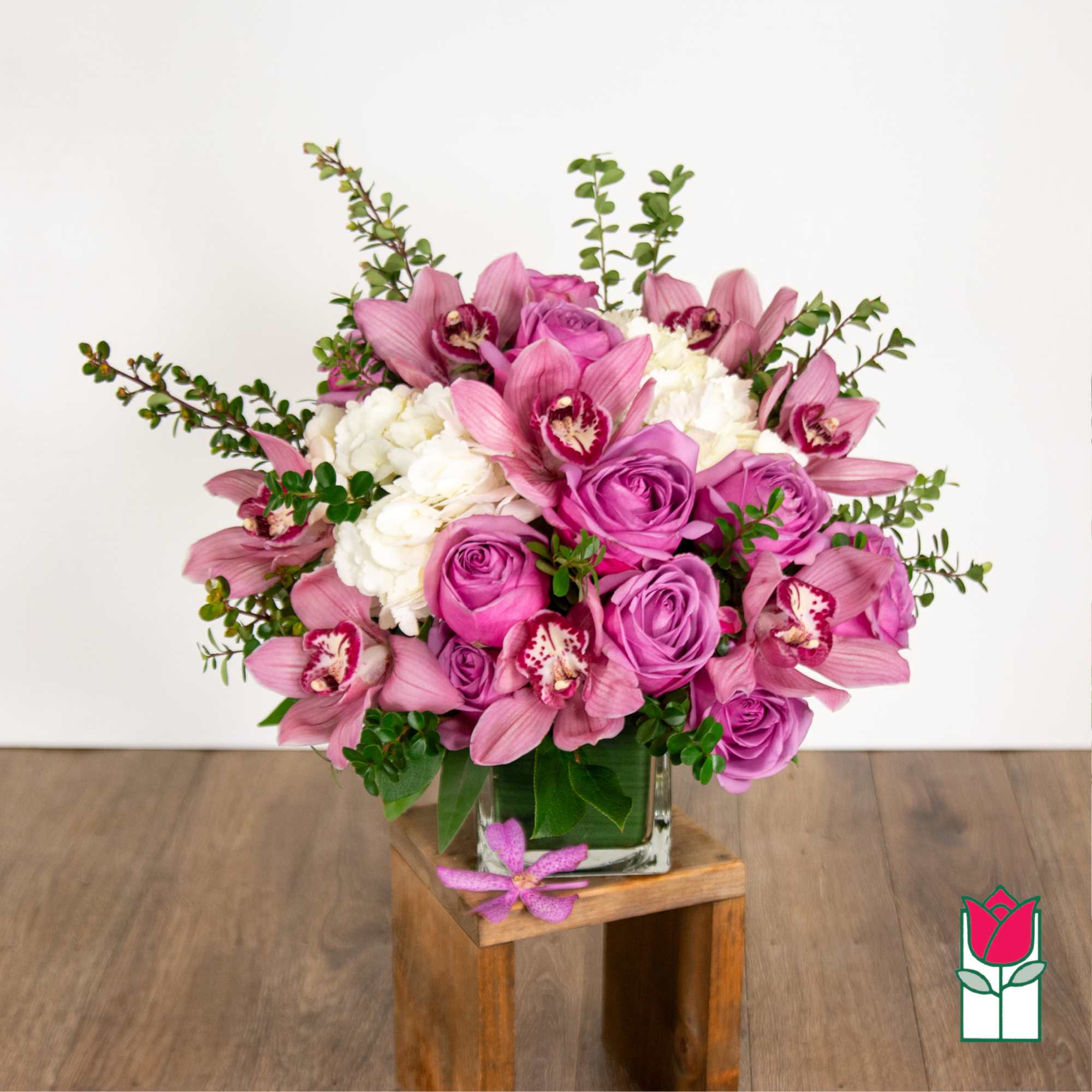 Pink orchid and rose bouquet in a clear glass vase
