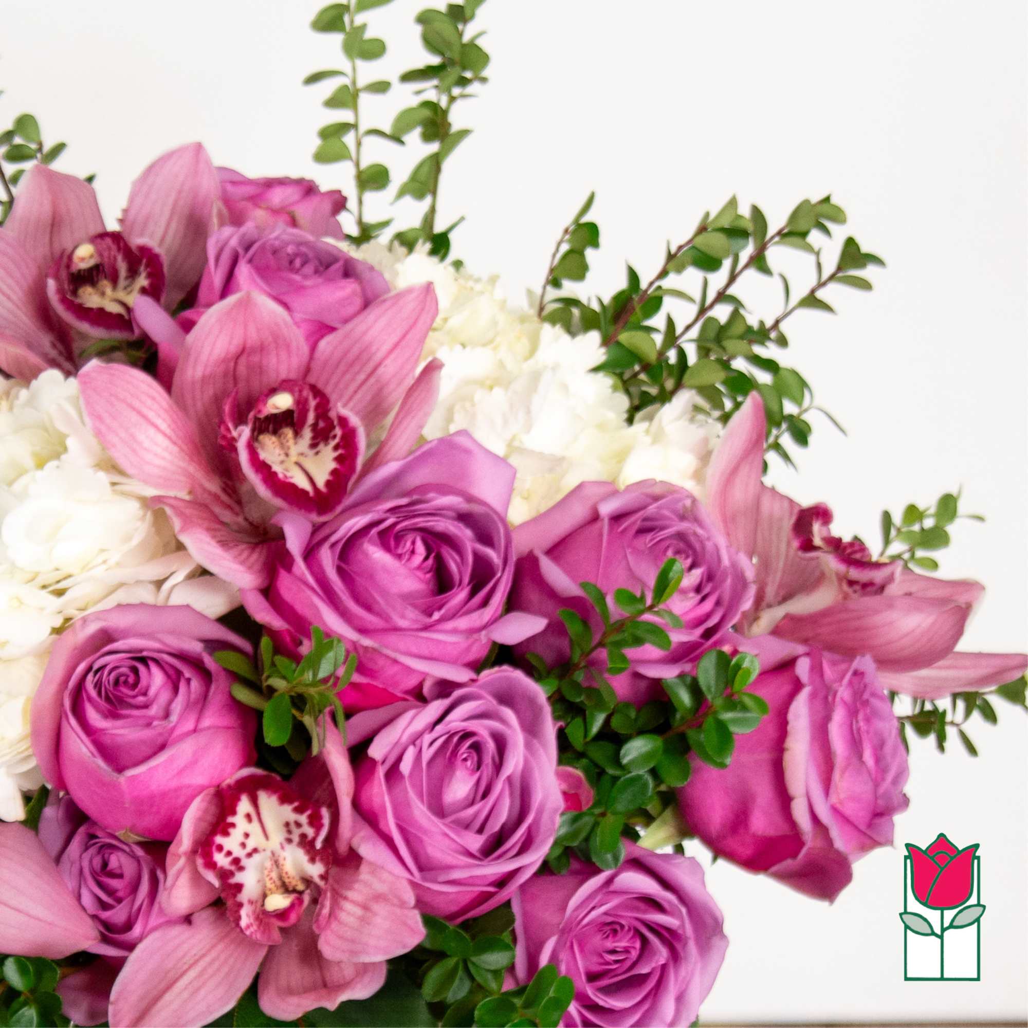 Pink roses and orchids with white blooms and greenery