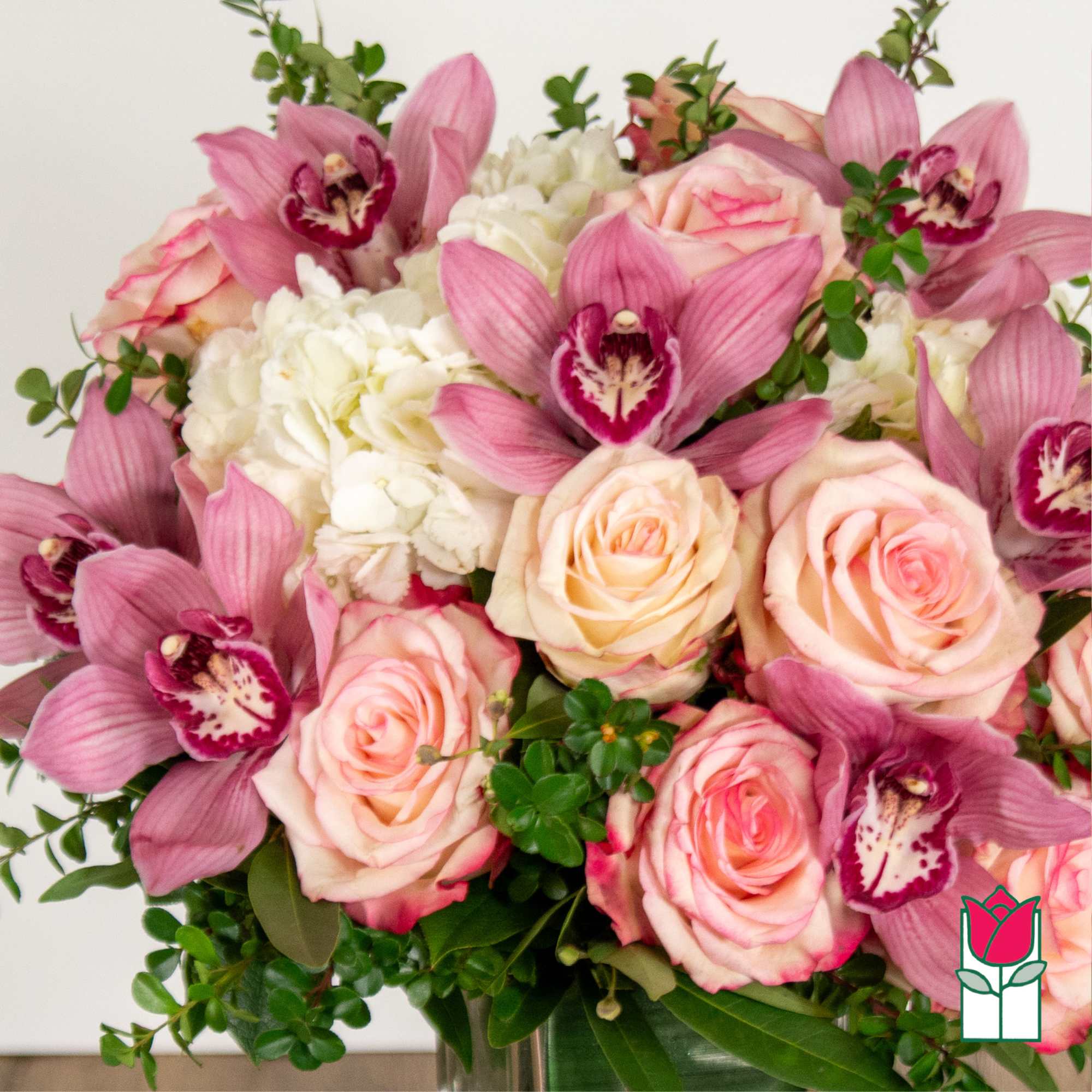 Pink orchids and blush roses with white hydrangea in a vase