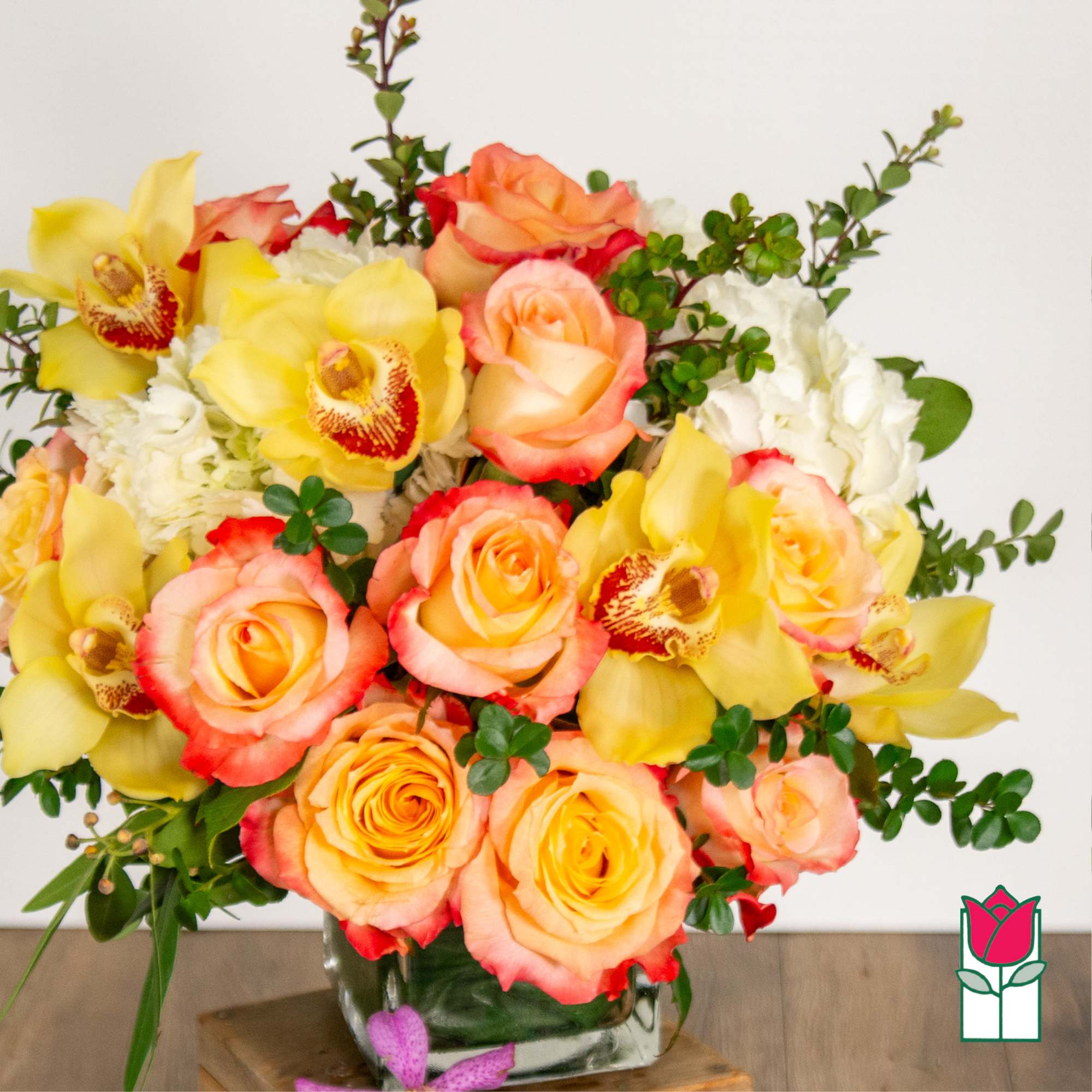 Bouquet of peach roses and yellow orchids in a glass vase