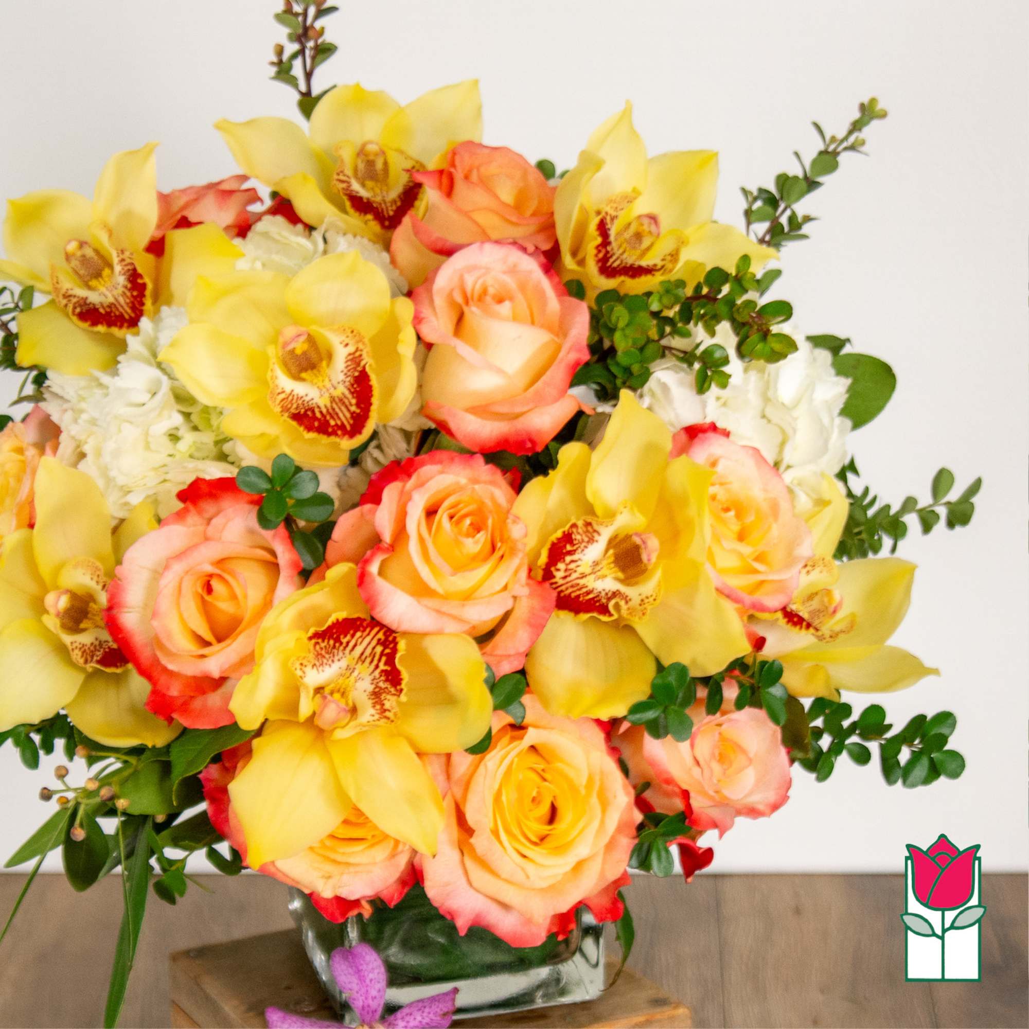 Bouquet of yellow orchids and peach roses in a glass vase, photo 2 of 5