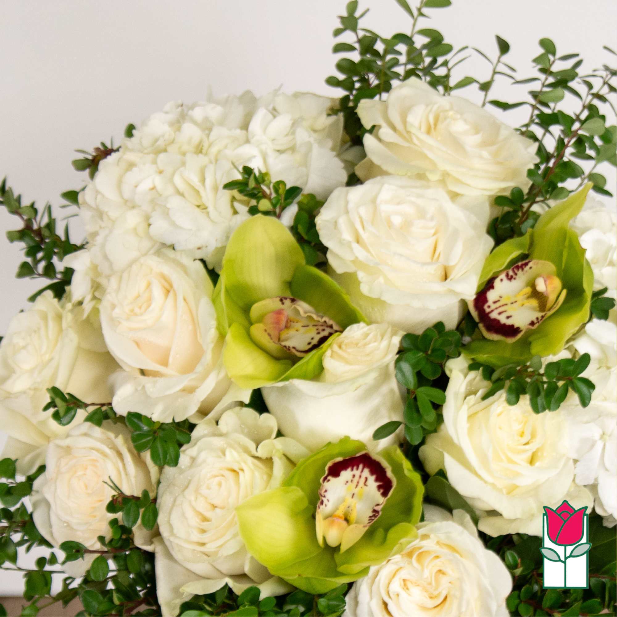 White roses and green orchids arranged with white hydrangea.