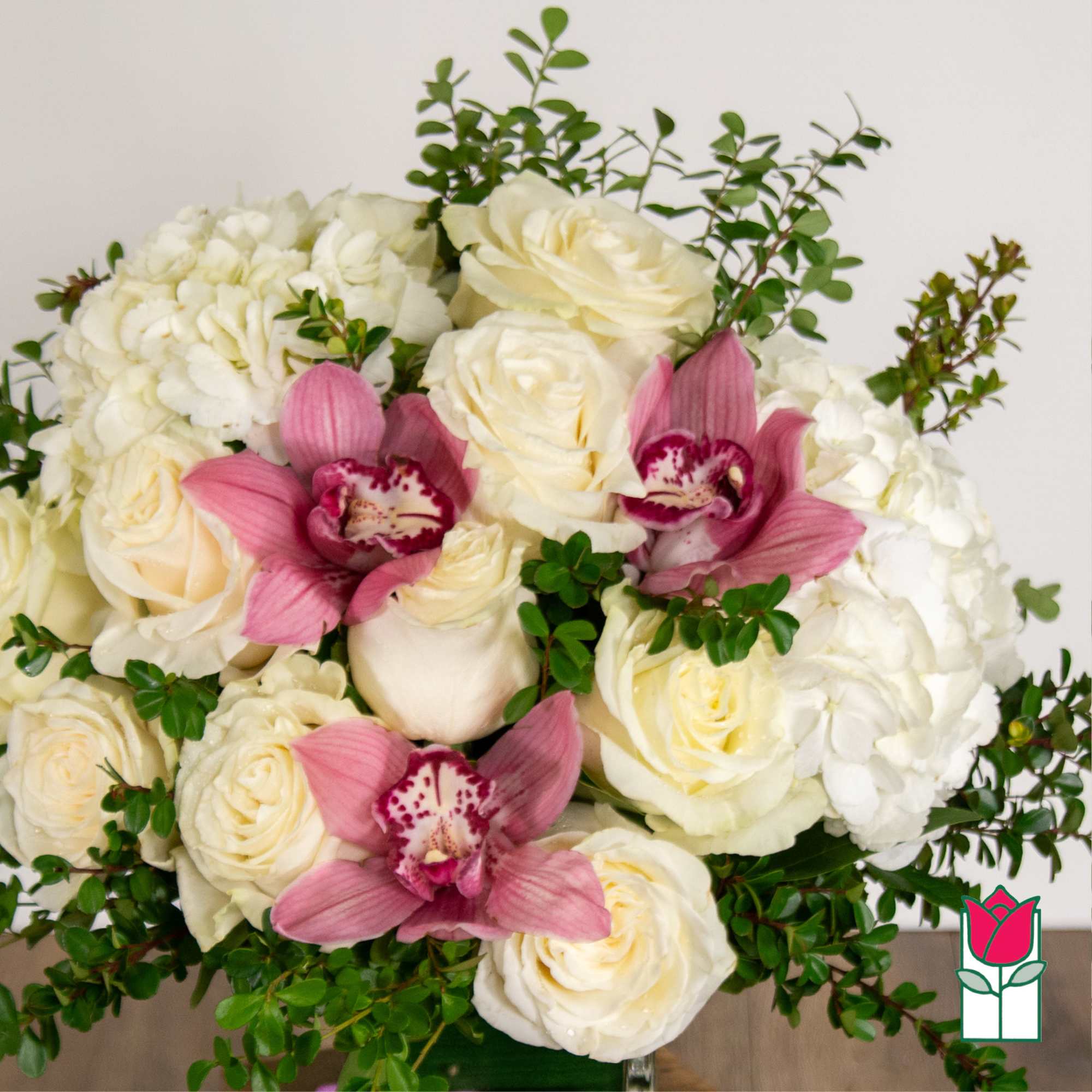 White roses and hydrangeas with pink orchids and greenery