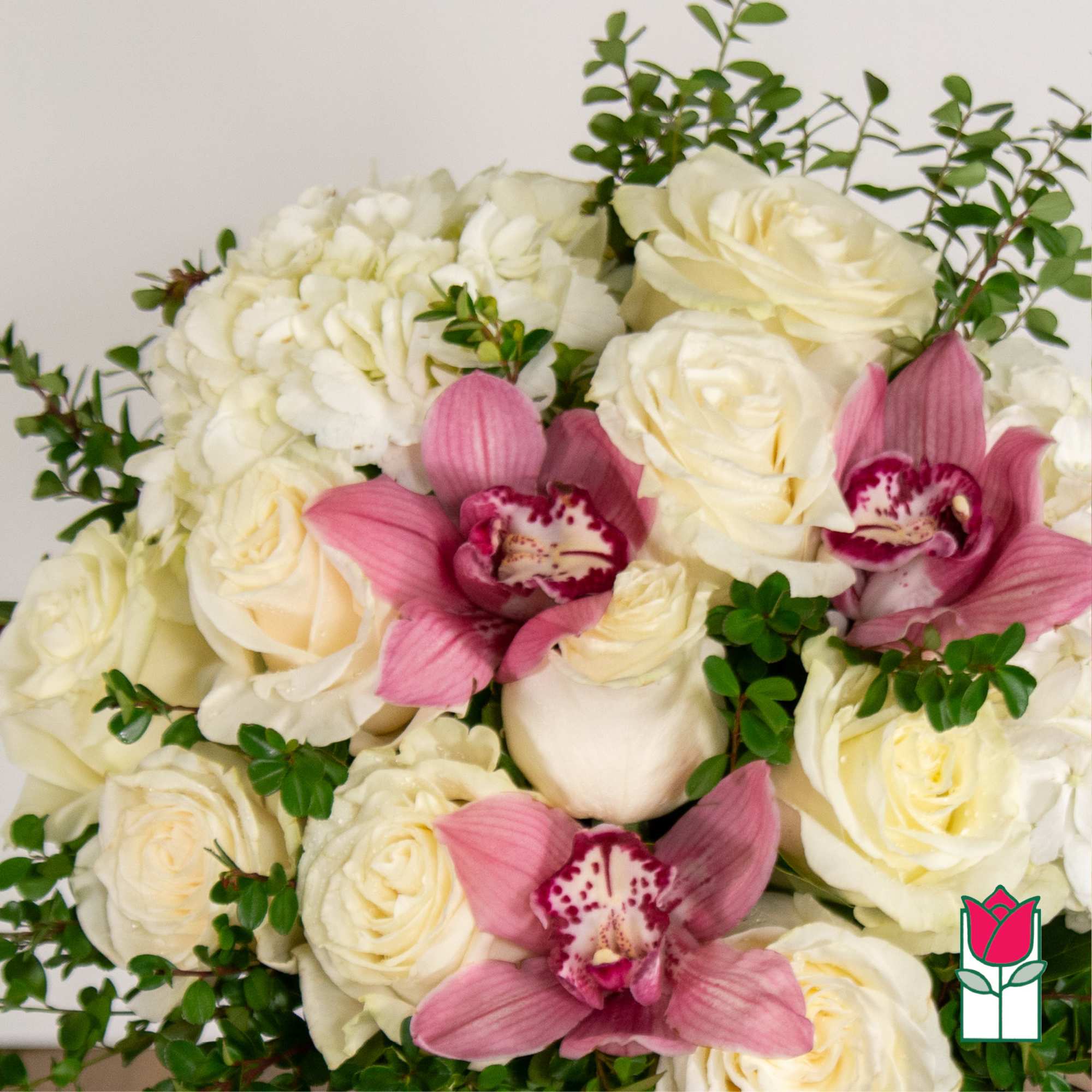 Bouquet of white roses and pink orchids with green foliage