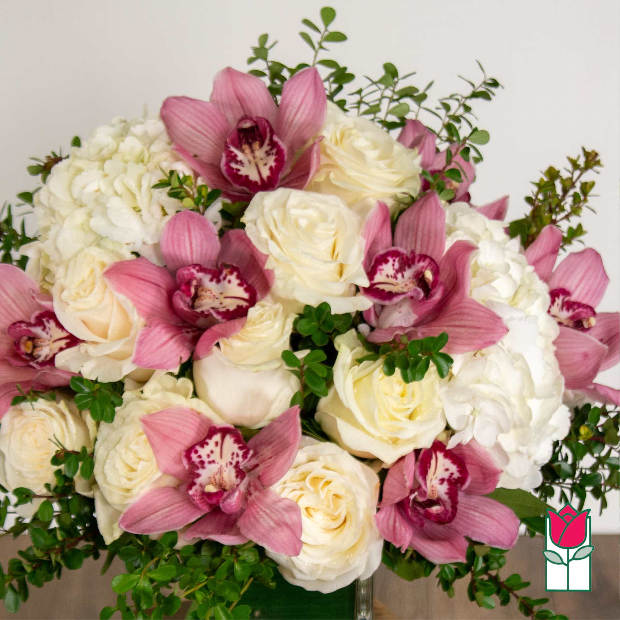 Pink orchids and white roses arranged in a bouquet