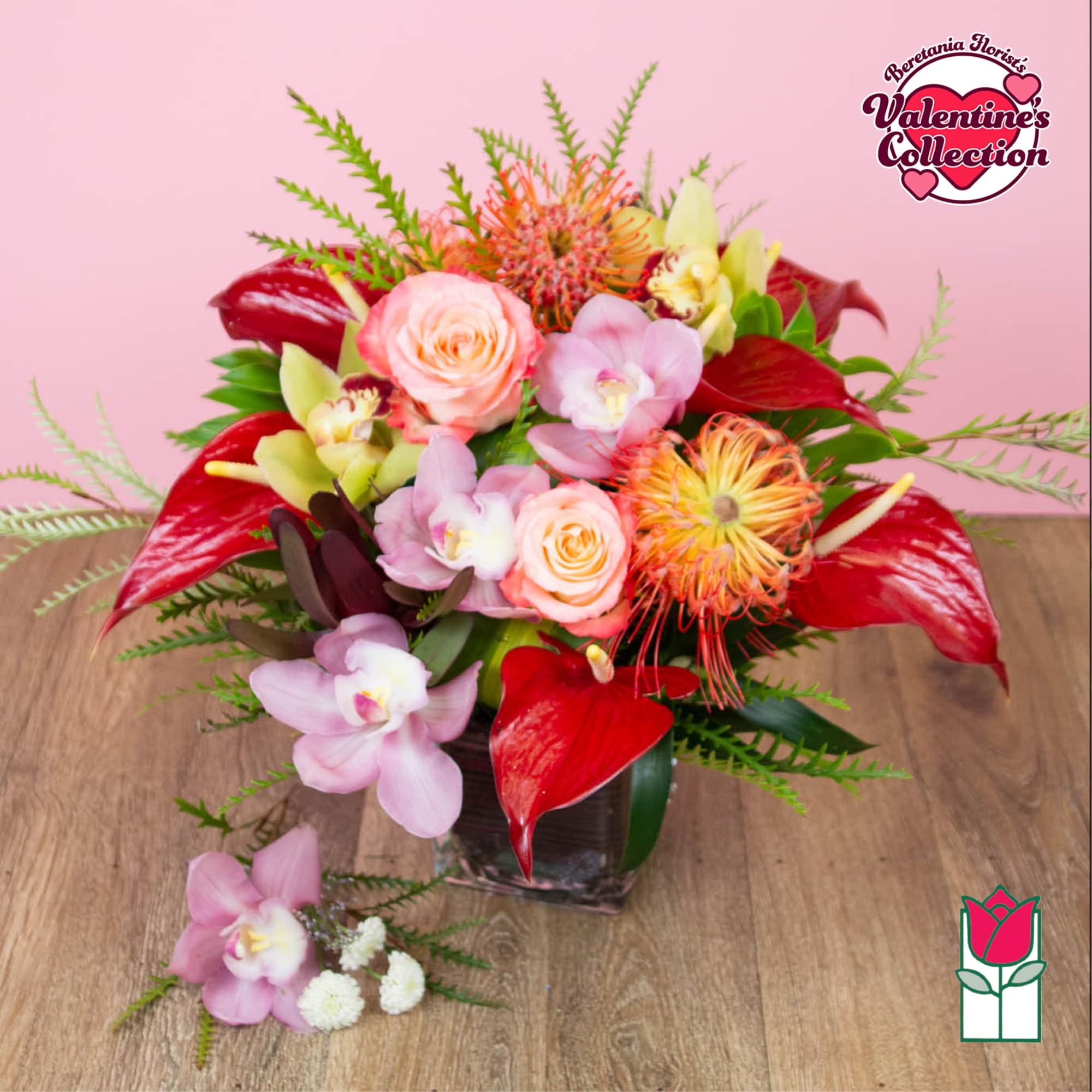 Pink and red floral arrangement in a square glass vase