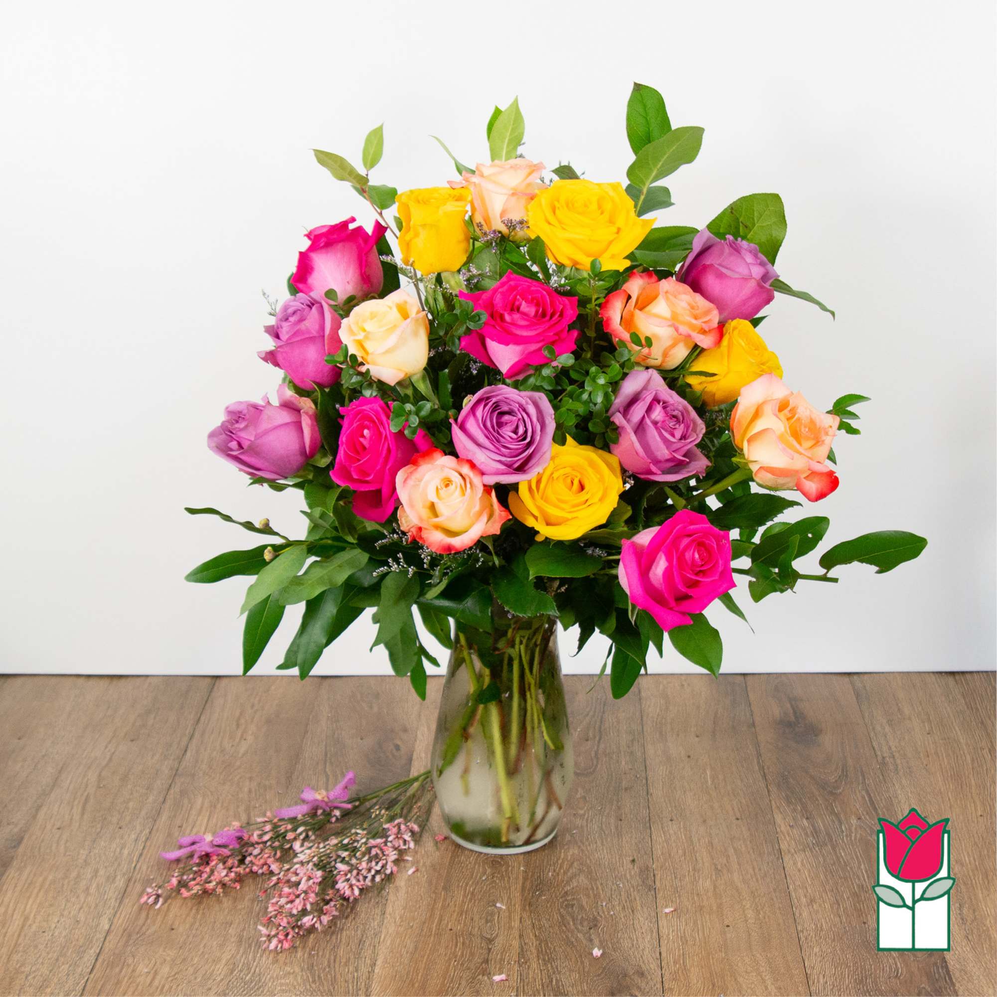 Mixed roses in a glass vase with pink filler flowers