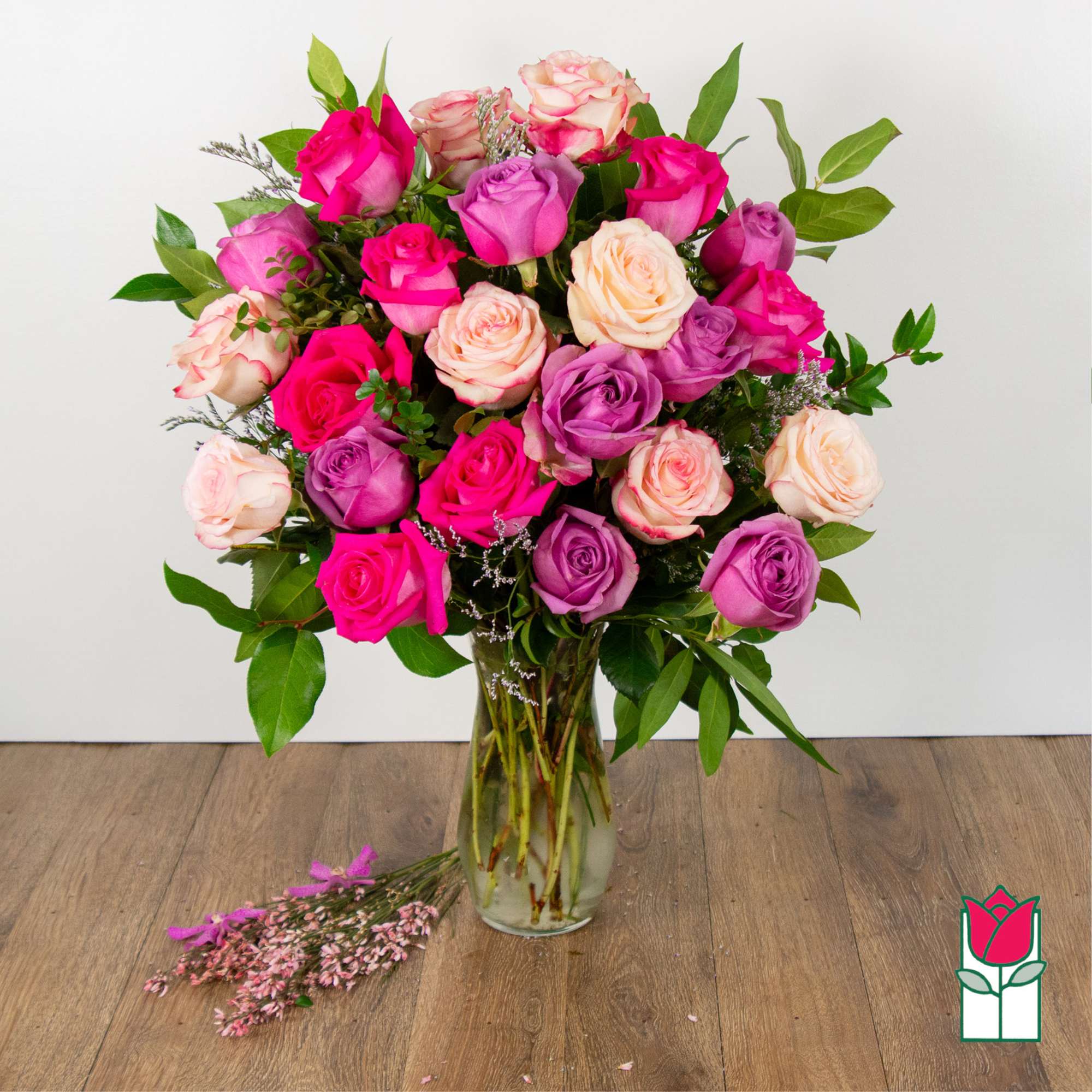 Bouquet of pink and lavender roses in a clear glass vase