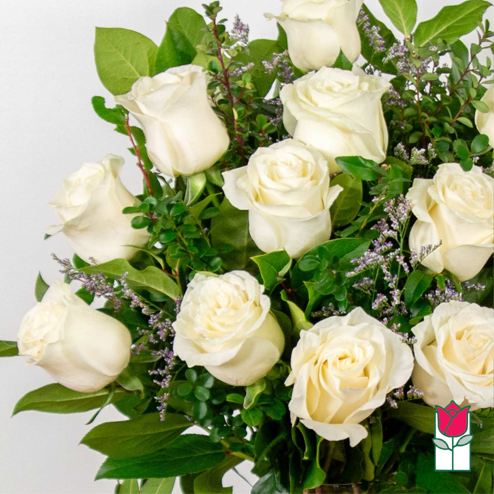 Bouquet of white roses with green foliage and purple filler flowers