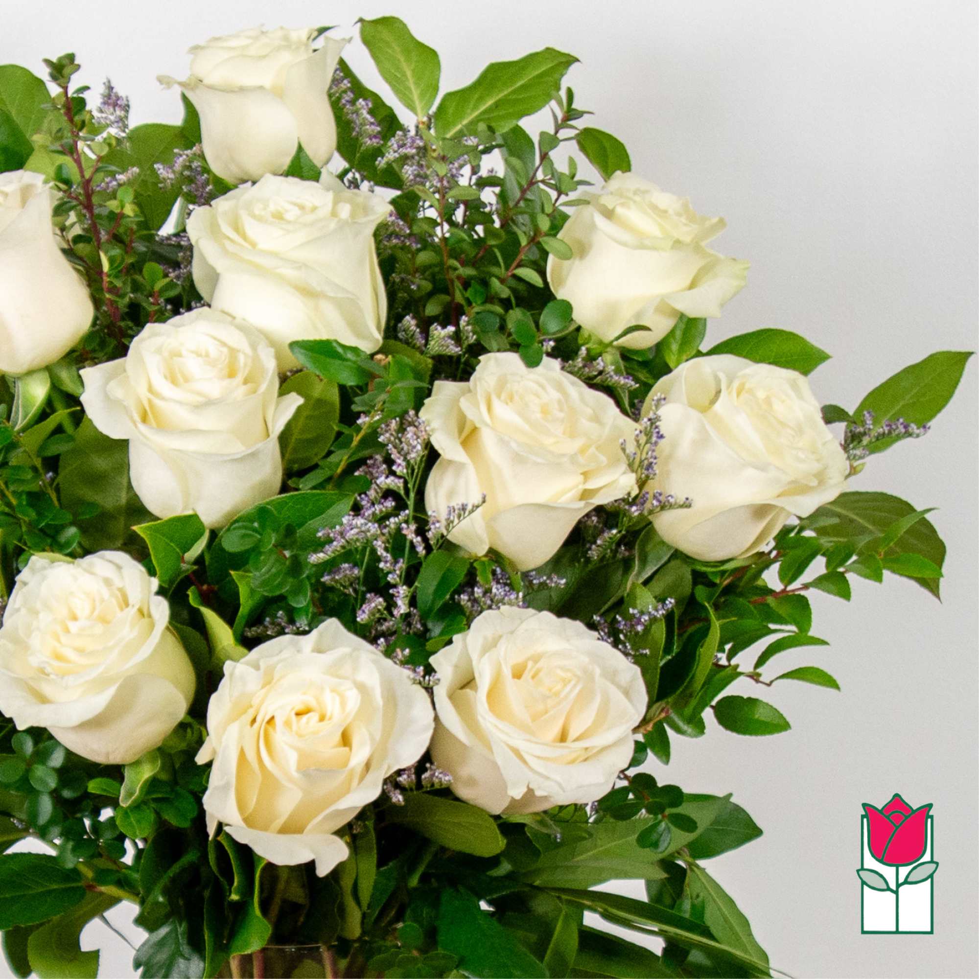 Bouquet of white roses with green foliage and small purple filler flowers