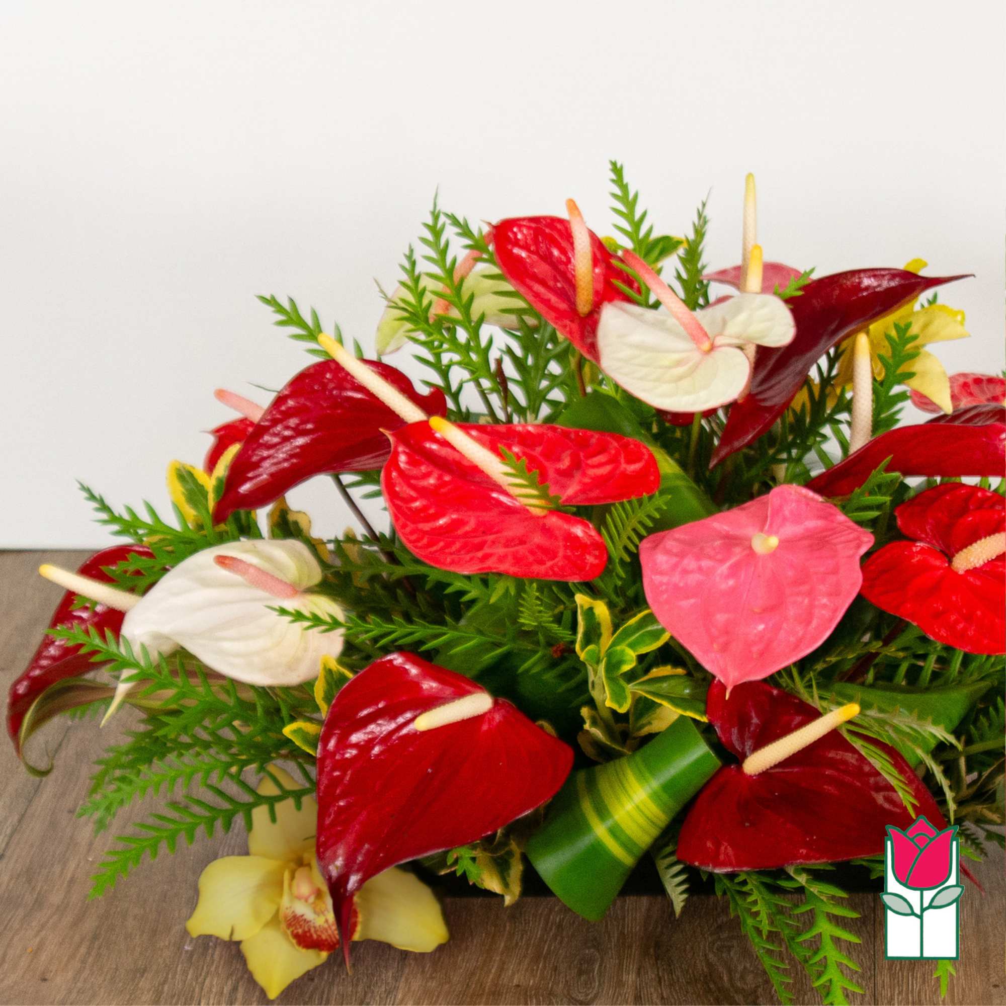 Arrangement of red, white, and pink anthuriums with greenery, photo 3 of 4