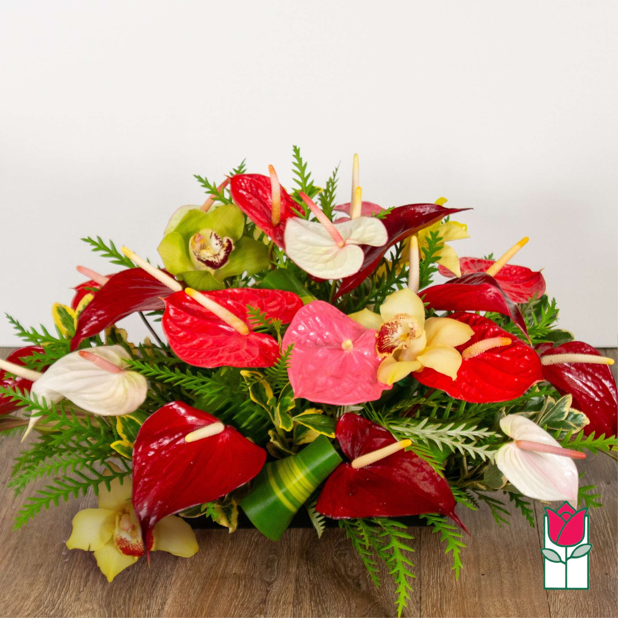Arrangement of red, pink, white, and yellow anthuriums with orchids