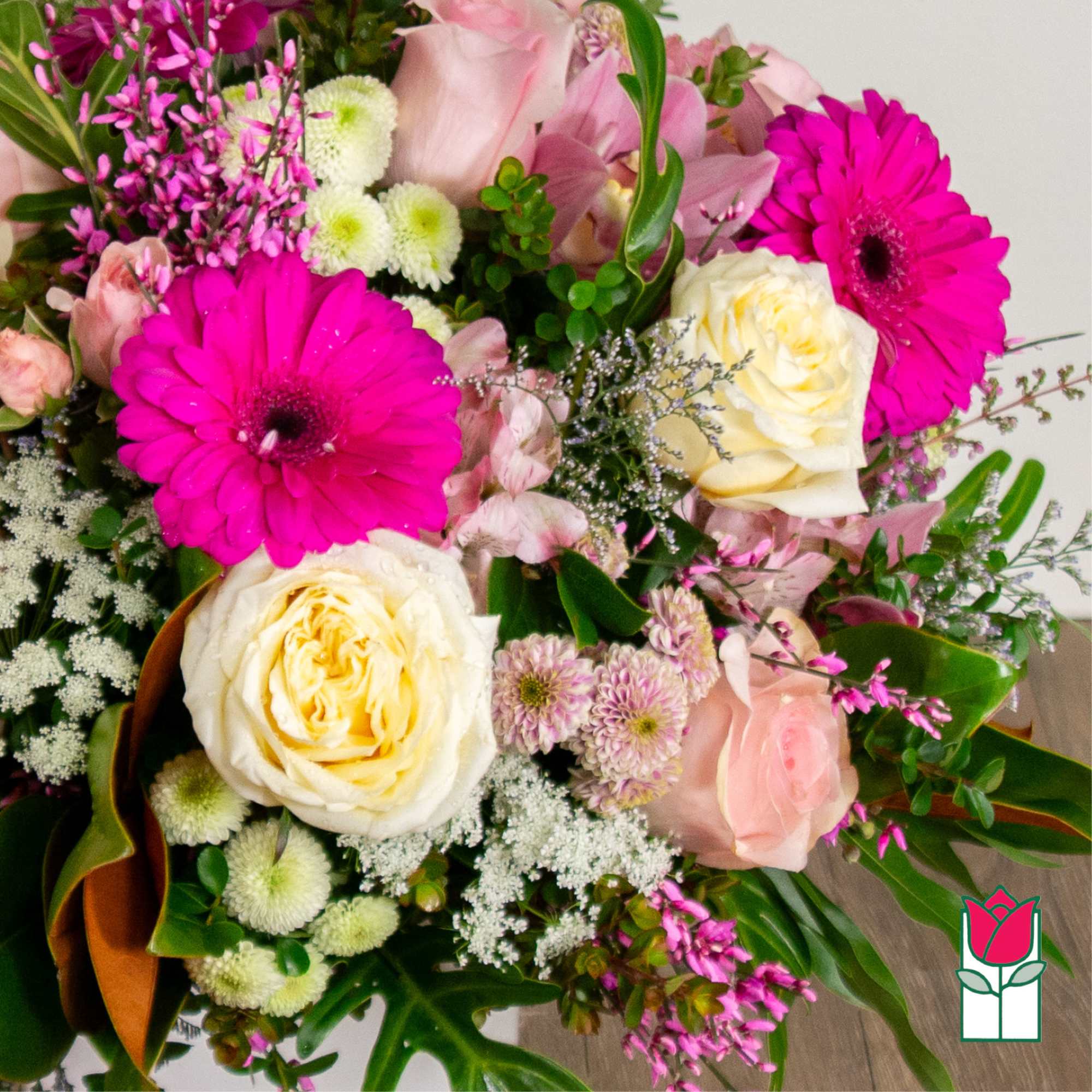 Bouquet of pink gerbera daisies and cream roses with mixed filler flowers