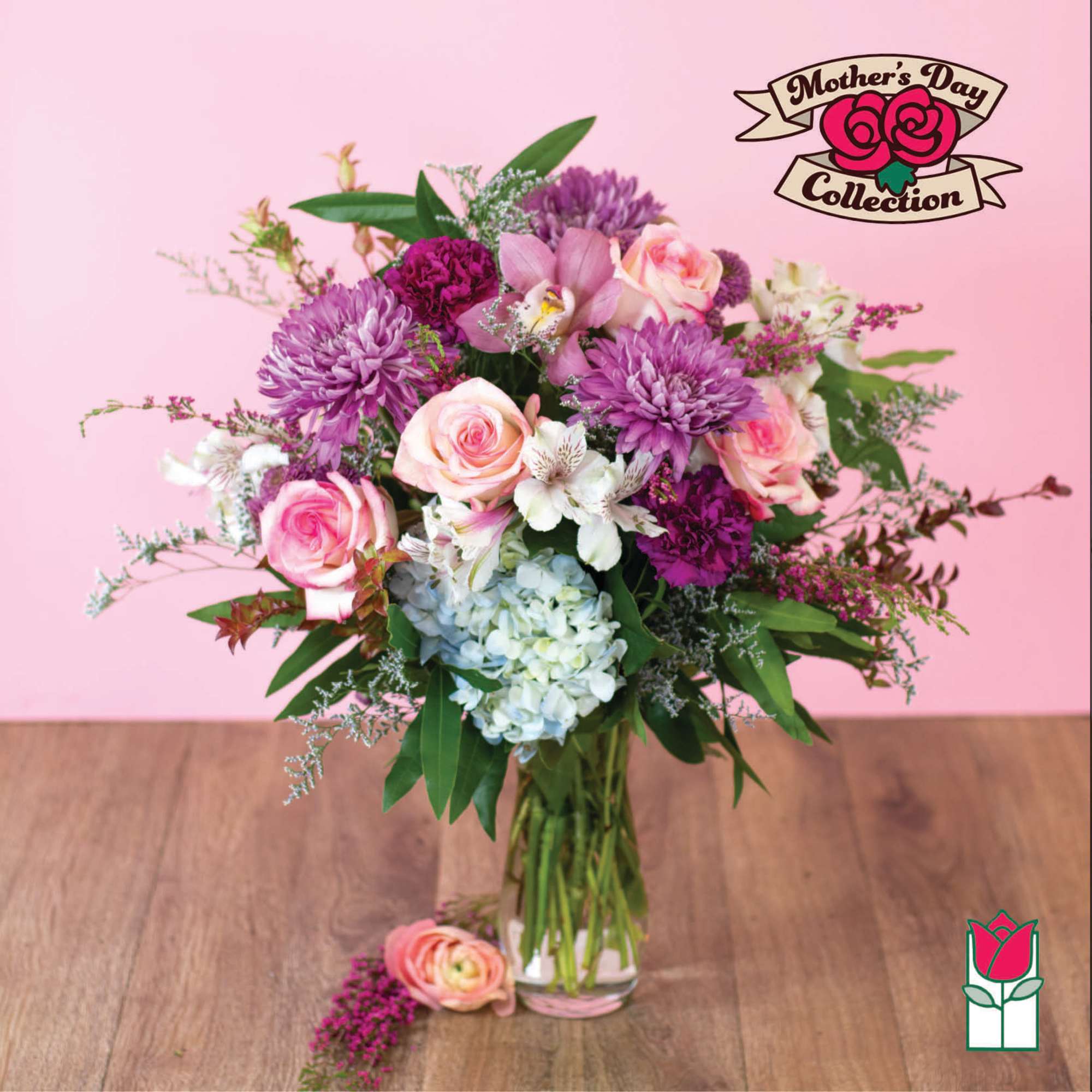 Tall mixed bouquet of pink roses, purple mums, hydrangea, and white blooms in a clear glass vase