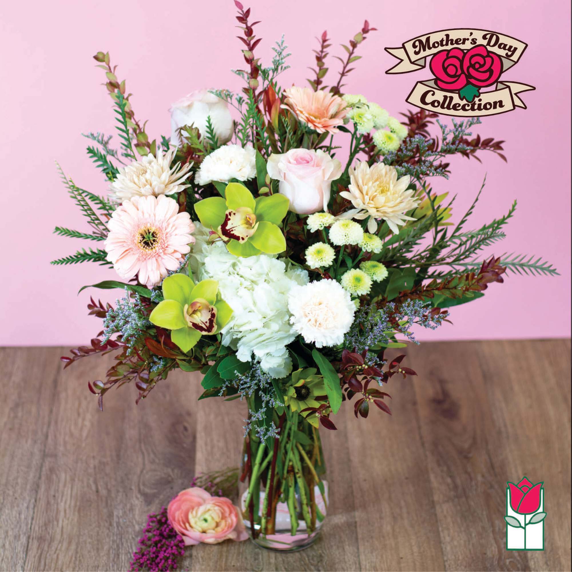 Mixed pastel bouquet in a clear glass vase with a Mother's Day sign.