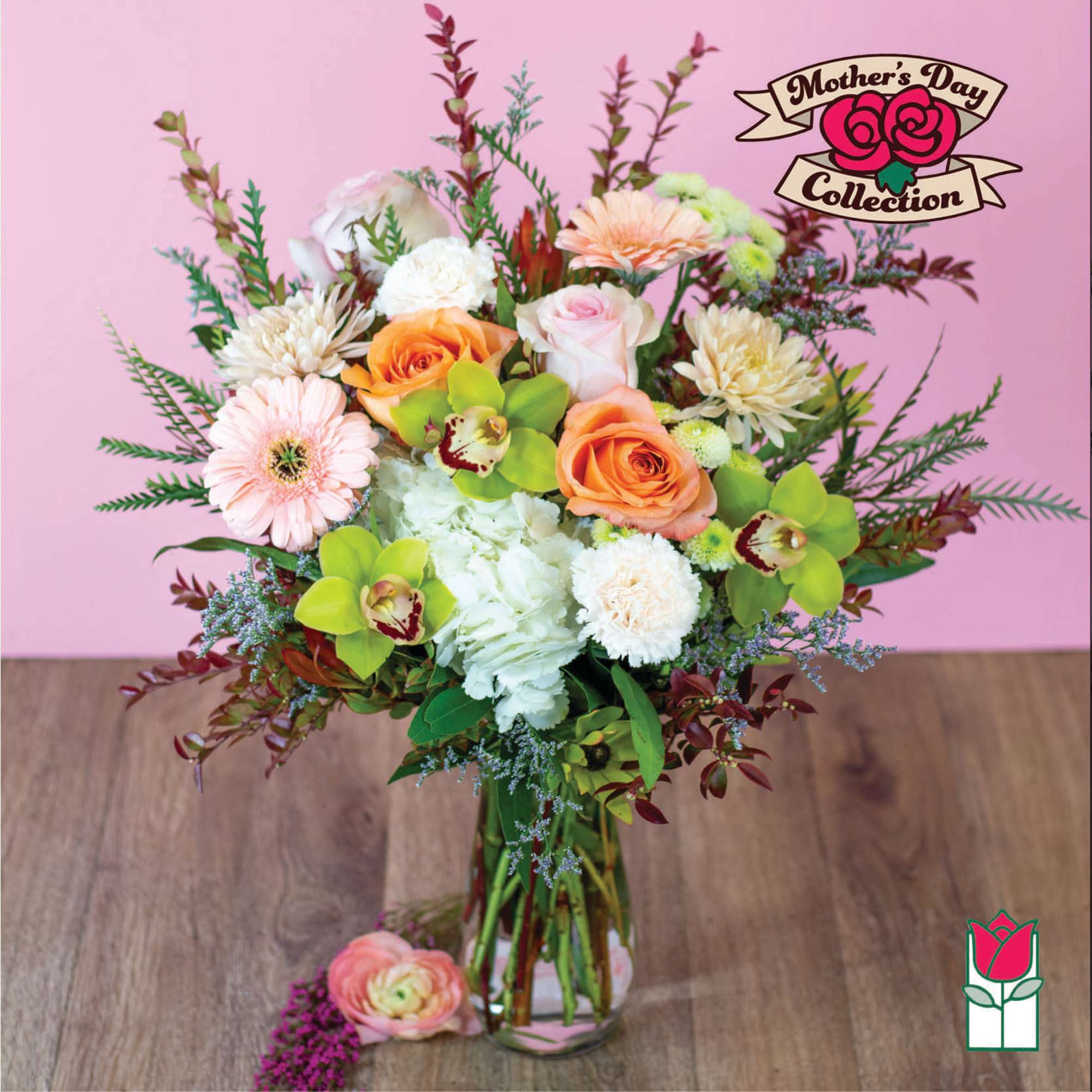 Mixed bouquet of roses, gerbera daisies, and orchids in a glass vase
