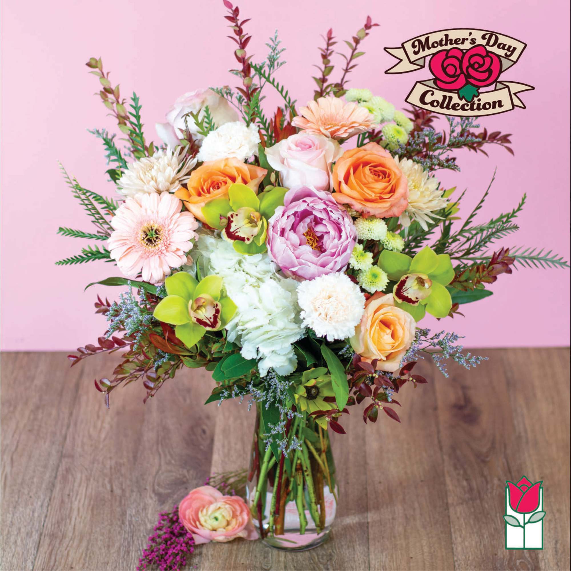 Mixed bouquet of roses, gerbera daisies, and orchids in a glass vase