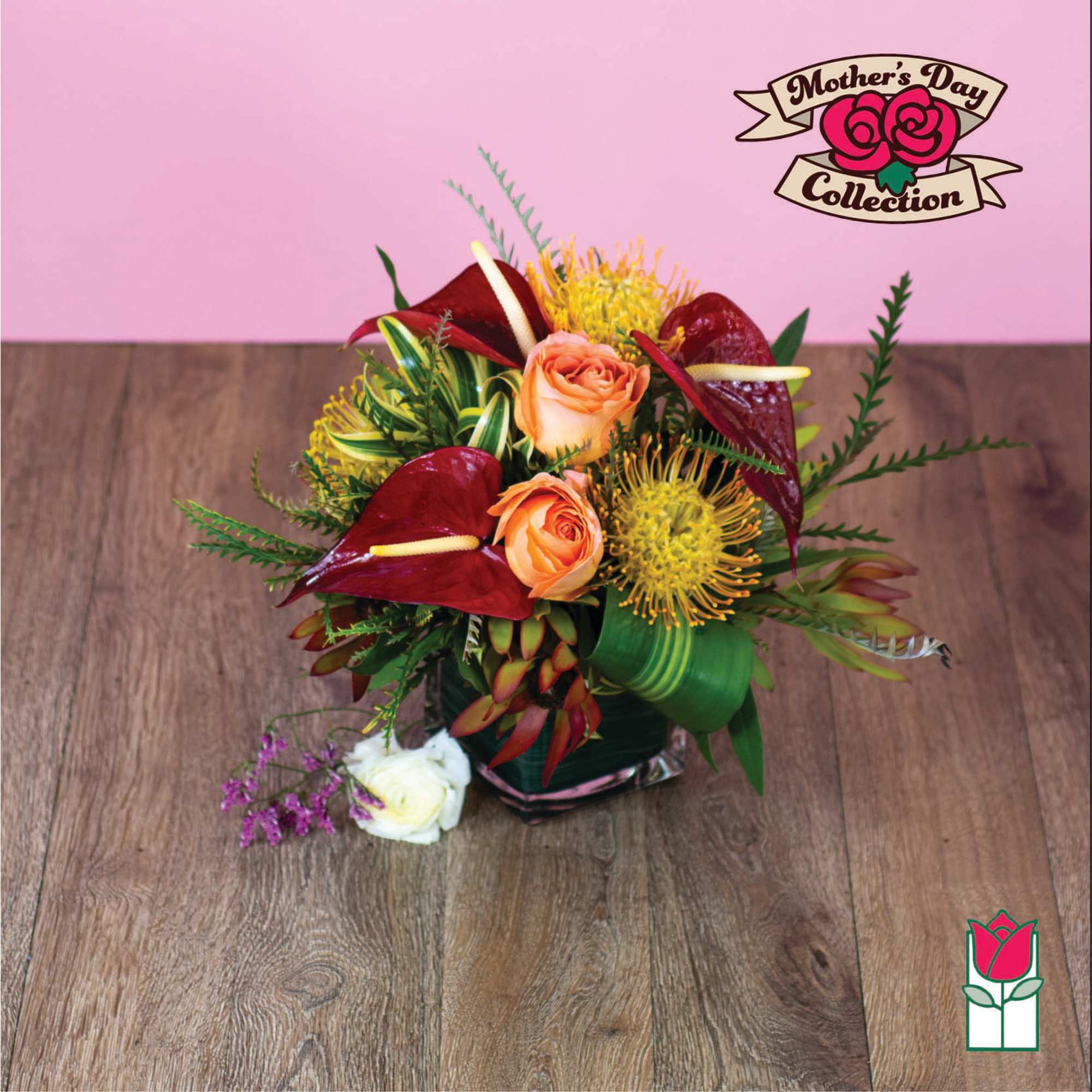 Tropical bouquet with orange roses and red anthuriums in a glass vase