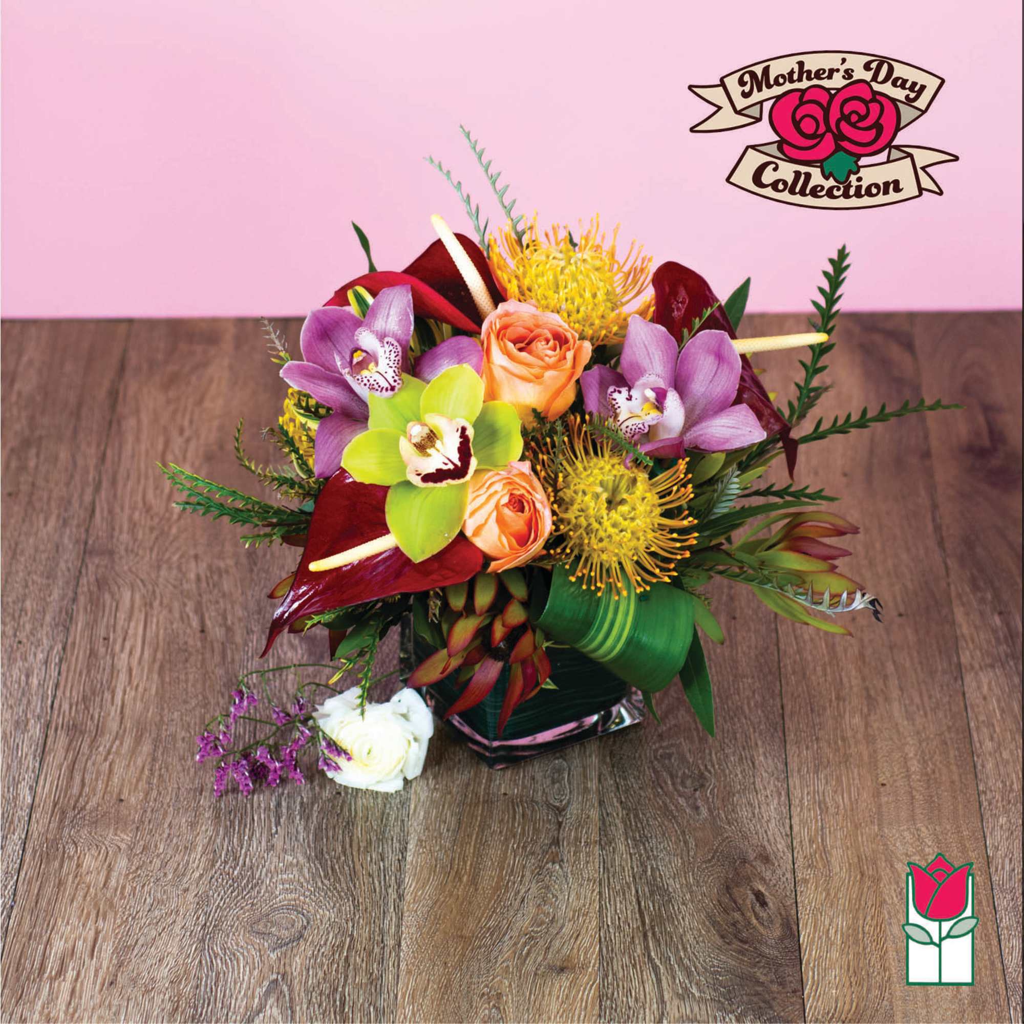 Mixed bouquet with orchids, roses, and yellow blooms in a glass vase