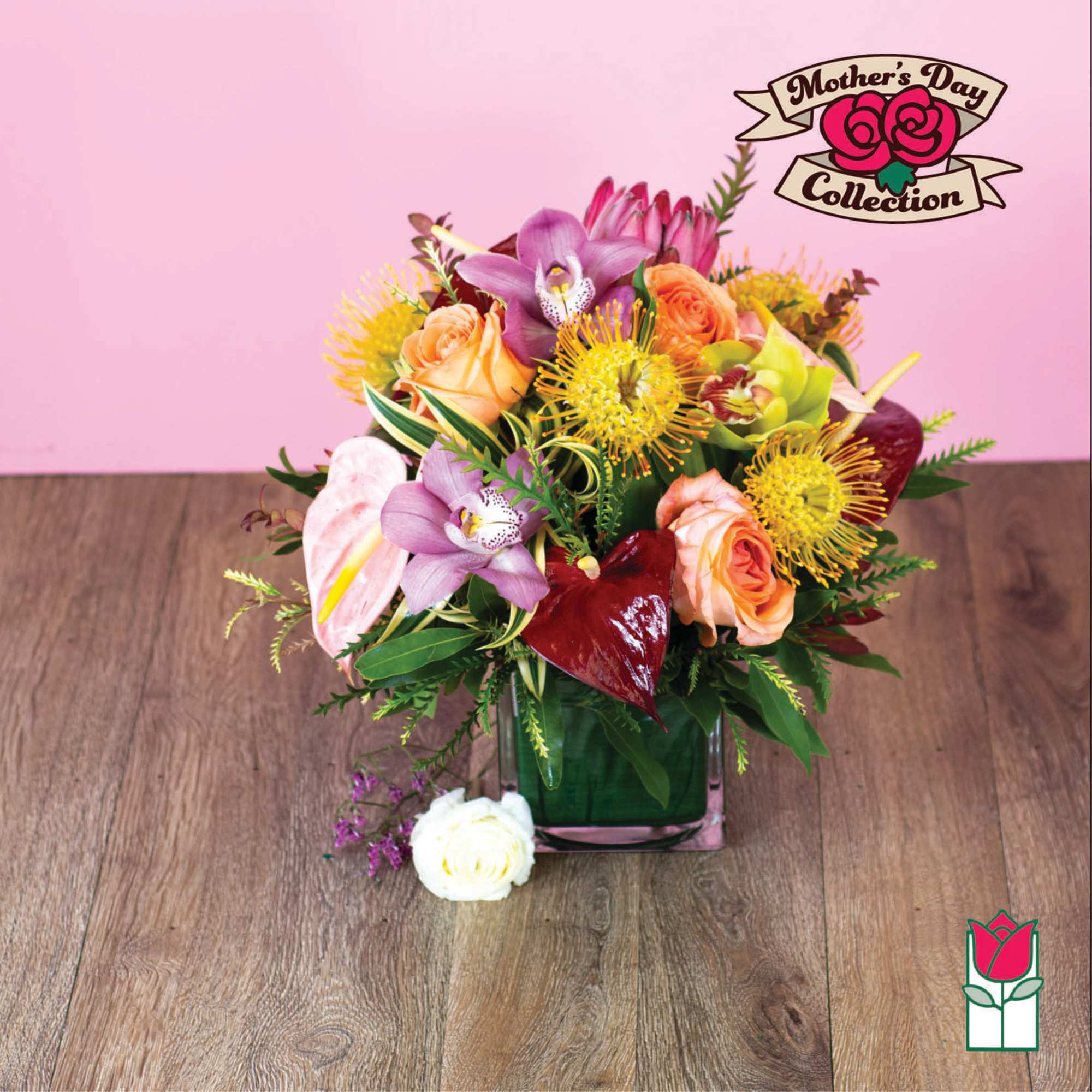 Mixed bouquet in a square glass vase with pink and orange blooms