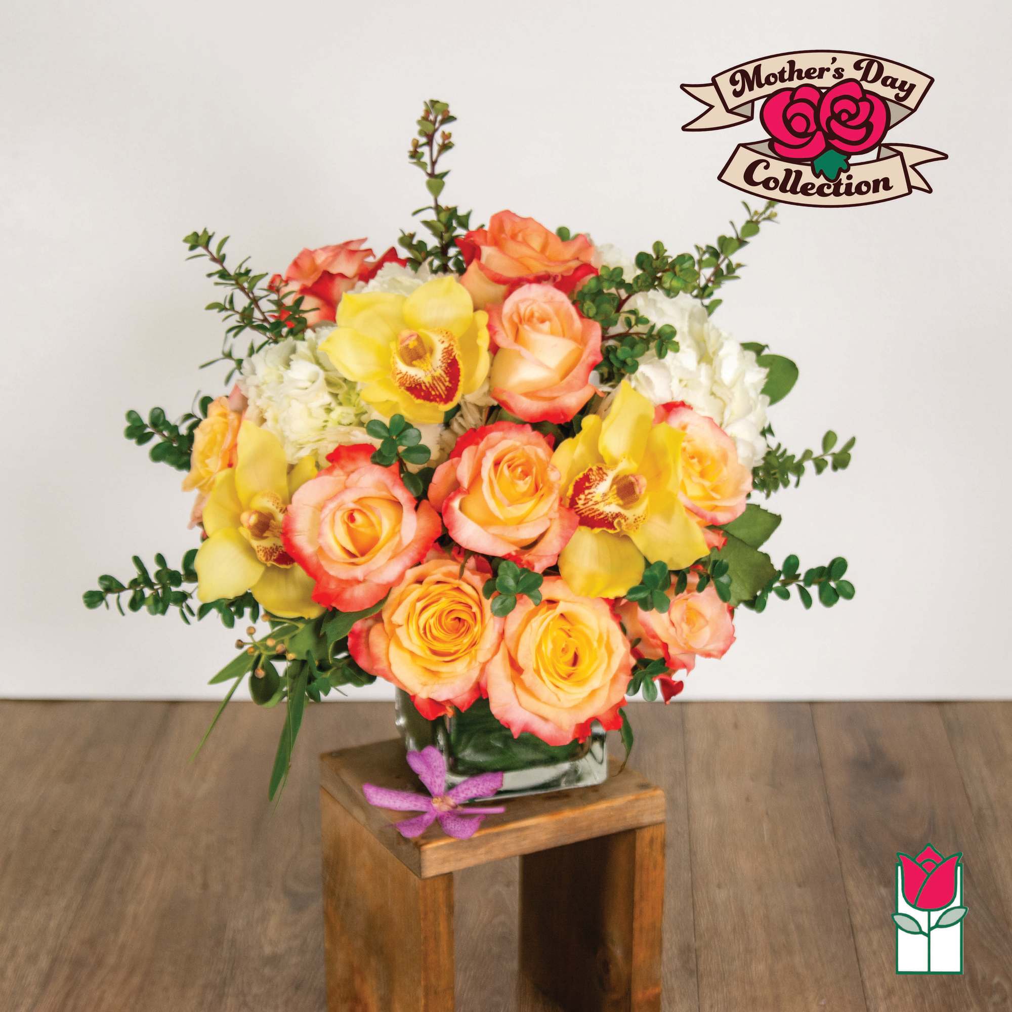 Bouquet of yellow and peach roses with orchids in a glass vase