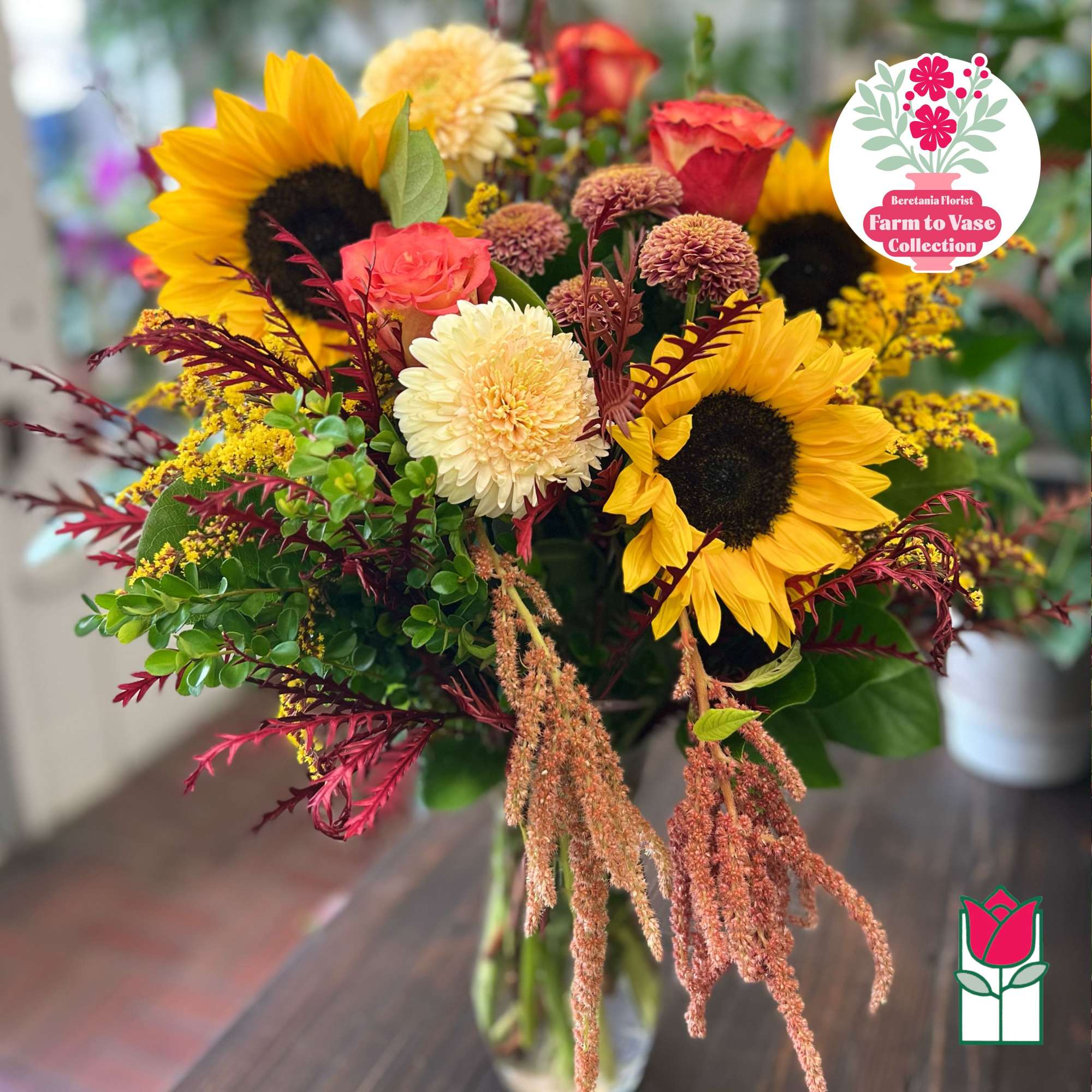 Bouquet with sunflowers, roses, and mums in a glass vase