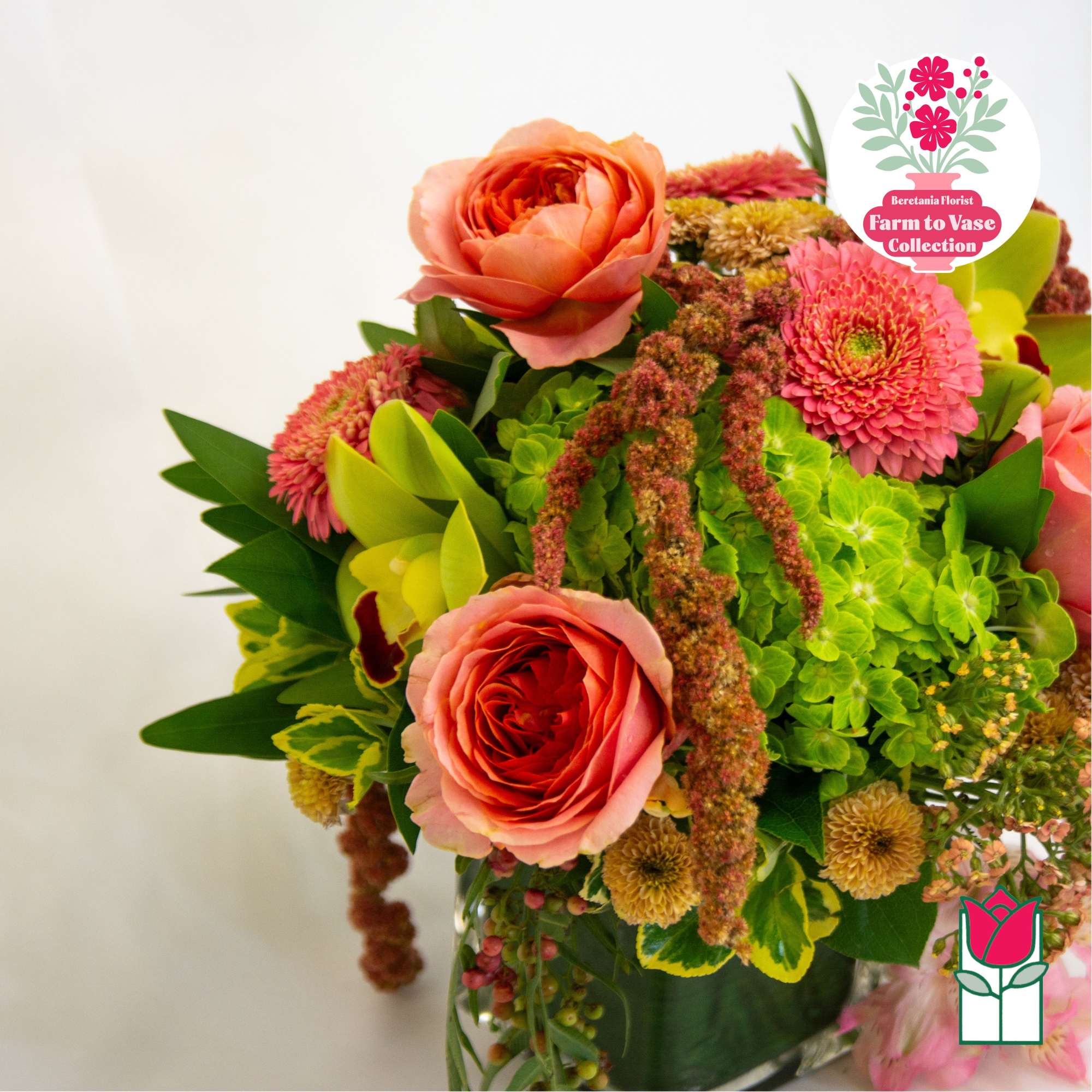 Bouquet of pink roses and bright mixed flowers in a glass vase