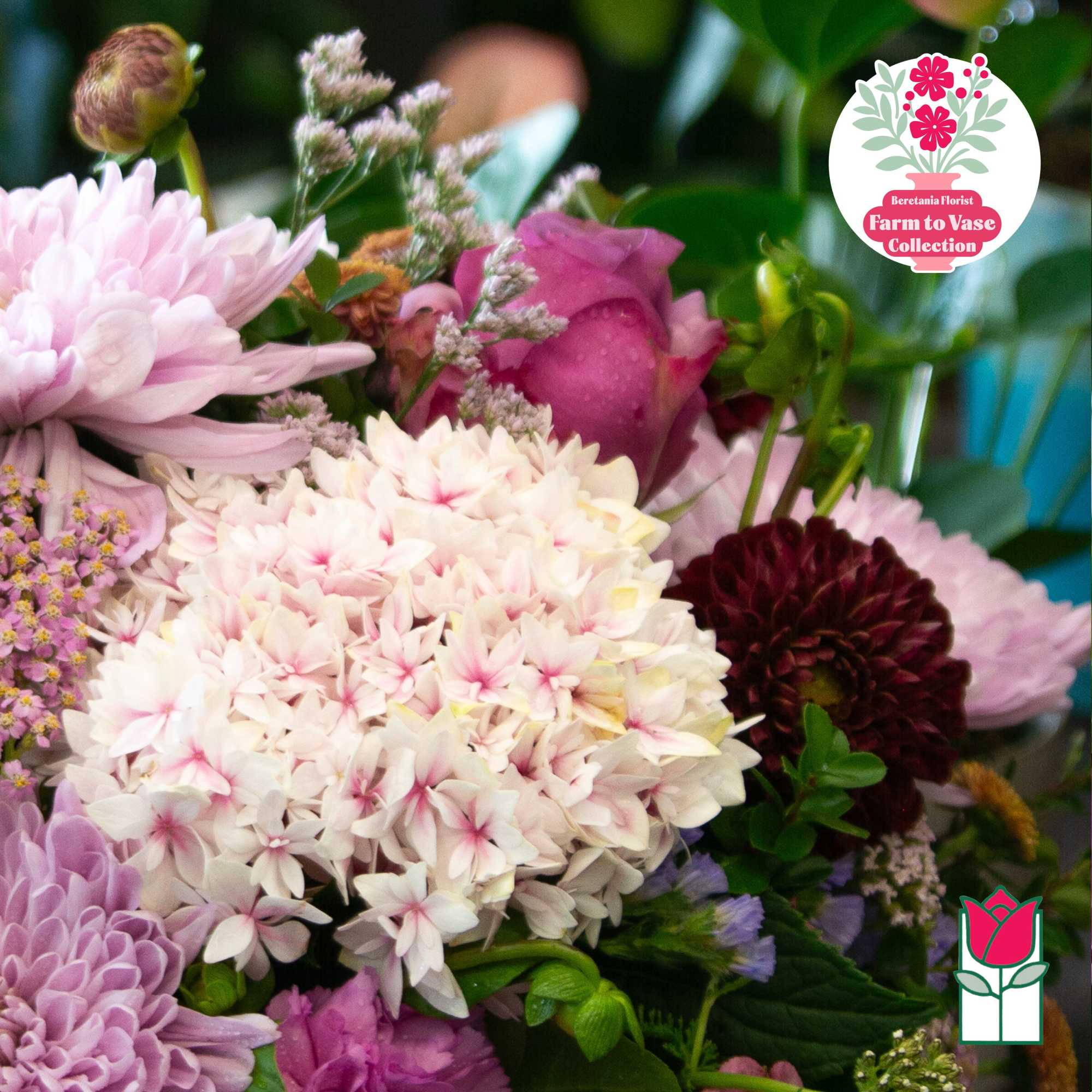 Mixed bouquet with pale pink and white flowers and a dark burgundy bloom