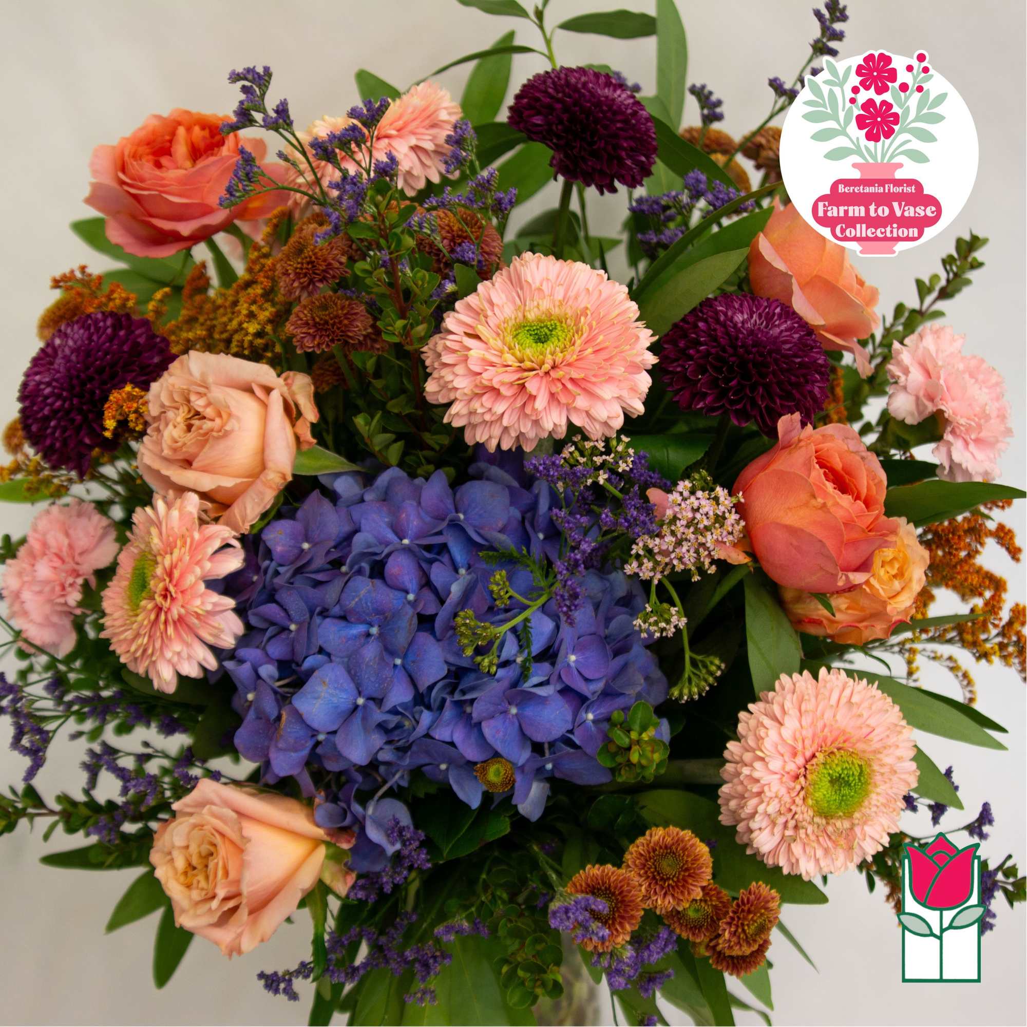 Mixed bouquet with blue hydrangea, peach roses, and pink daisies
