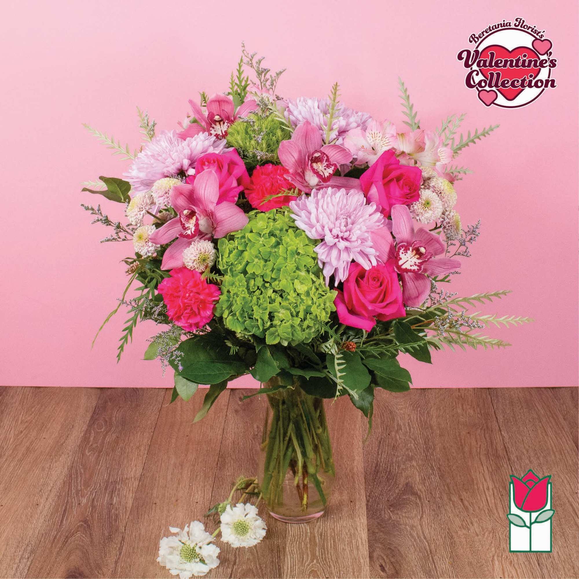 Pink and green bouquet in a glass vase with roses and orchids