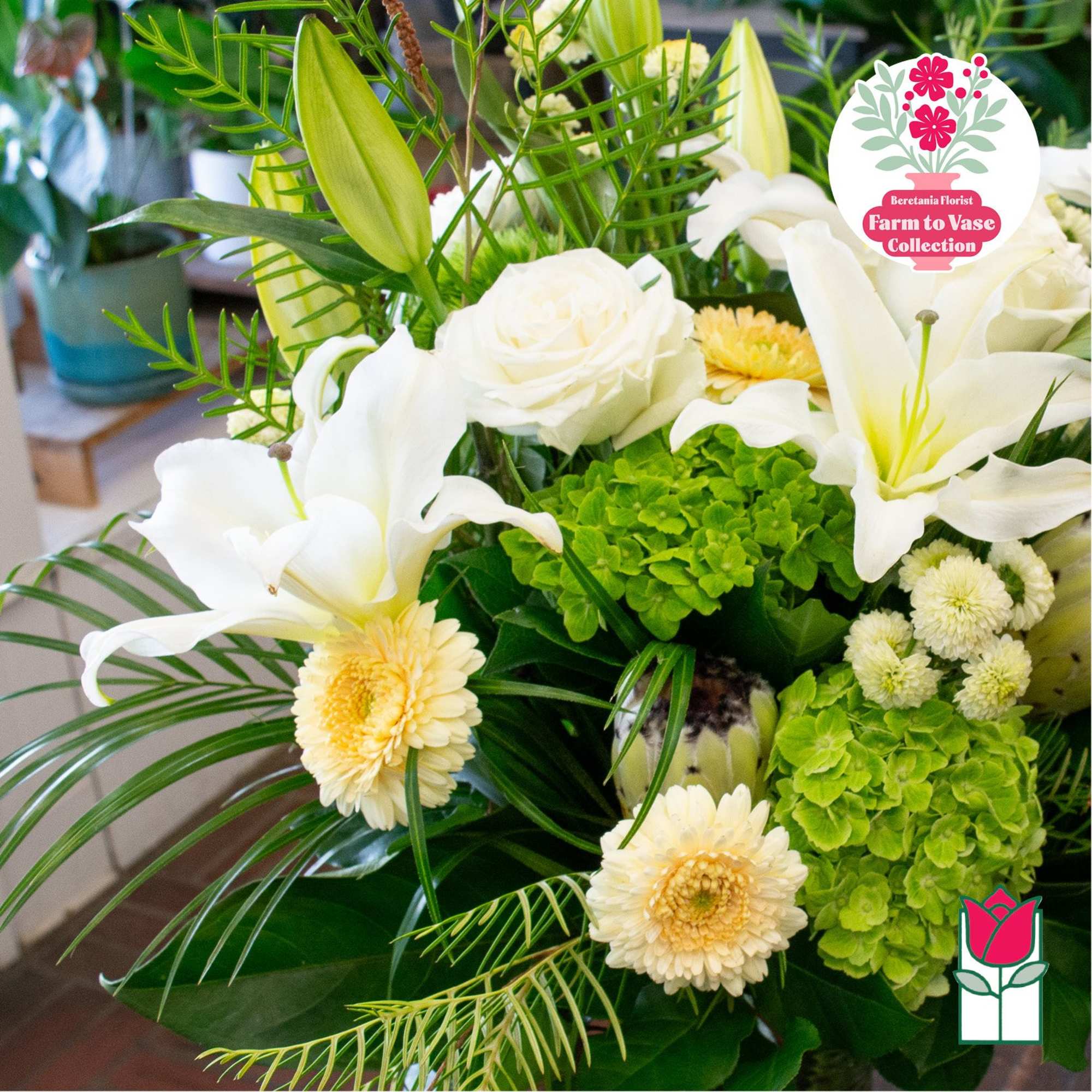White lilies and cream flowers arranged with bright green hydrangeas
