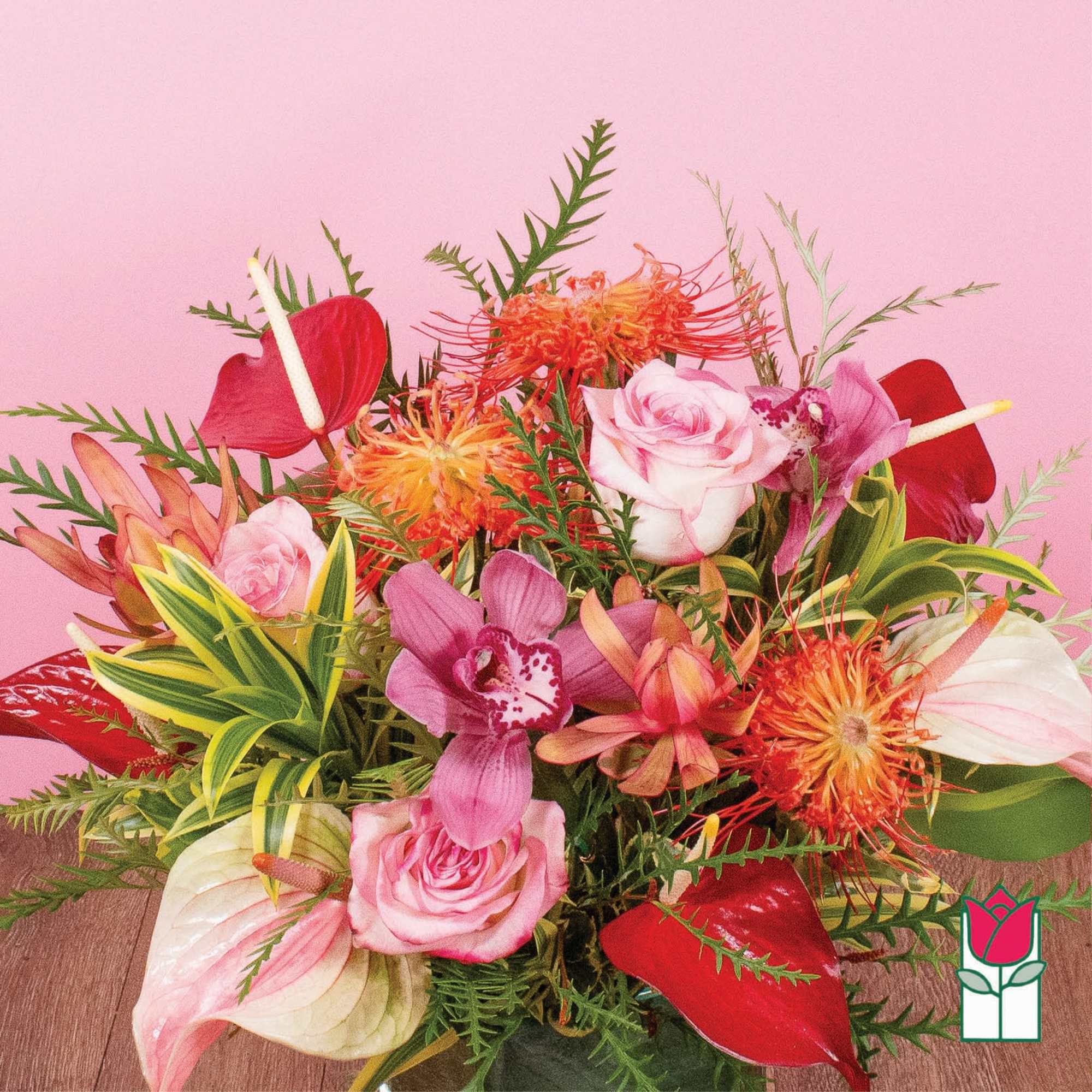 Colorful arrangement of pink roses, orchids, red anthurium and orange protea in a vase