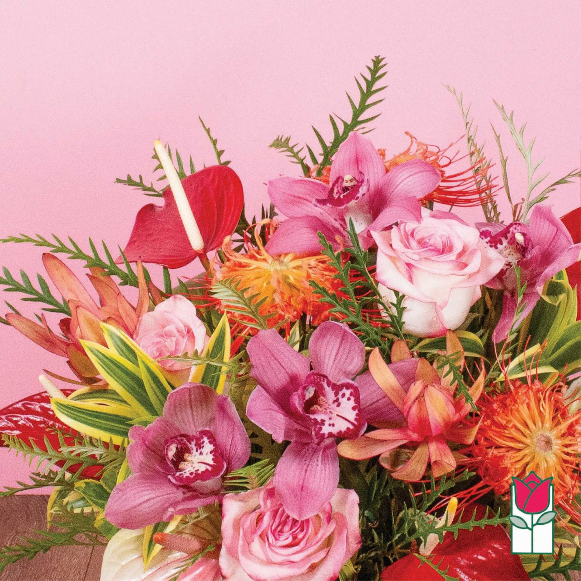 Bright arrangement of pink orchids, roses, and orange tropical flowers against a pink background