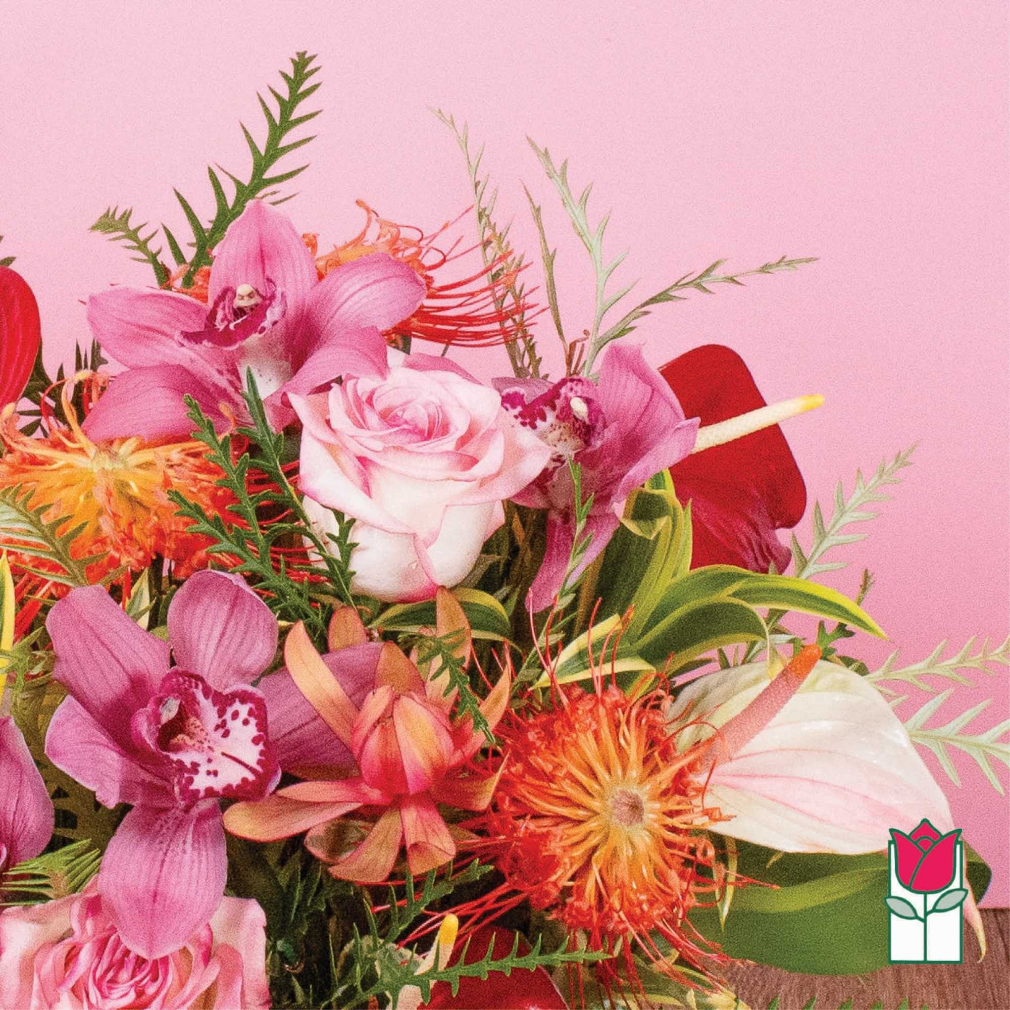 Bright arrangement of pink roses, orchids, and orange protea blooms against a pink background