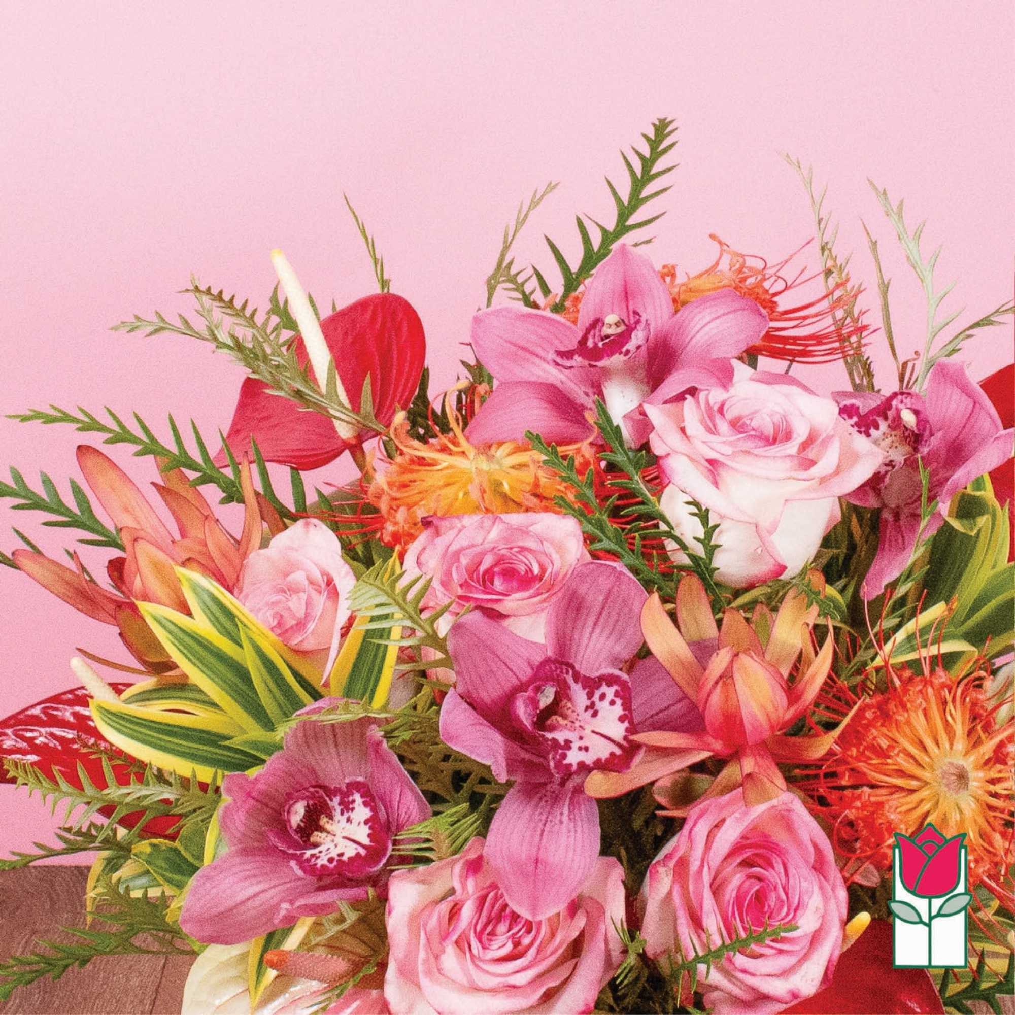 Bright bouquet of pink roses, cymbidium orchids, and orange tropical blooms against a pink background.