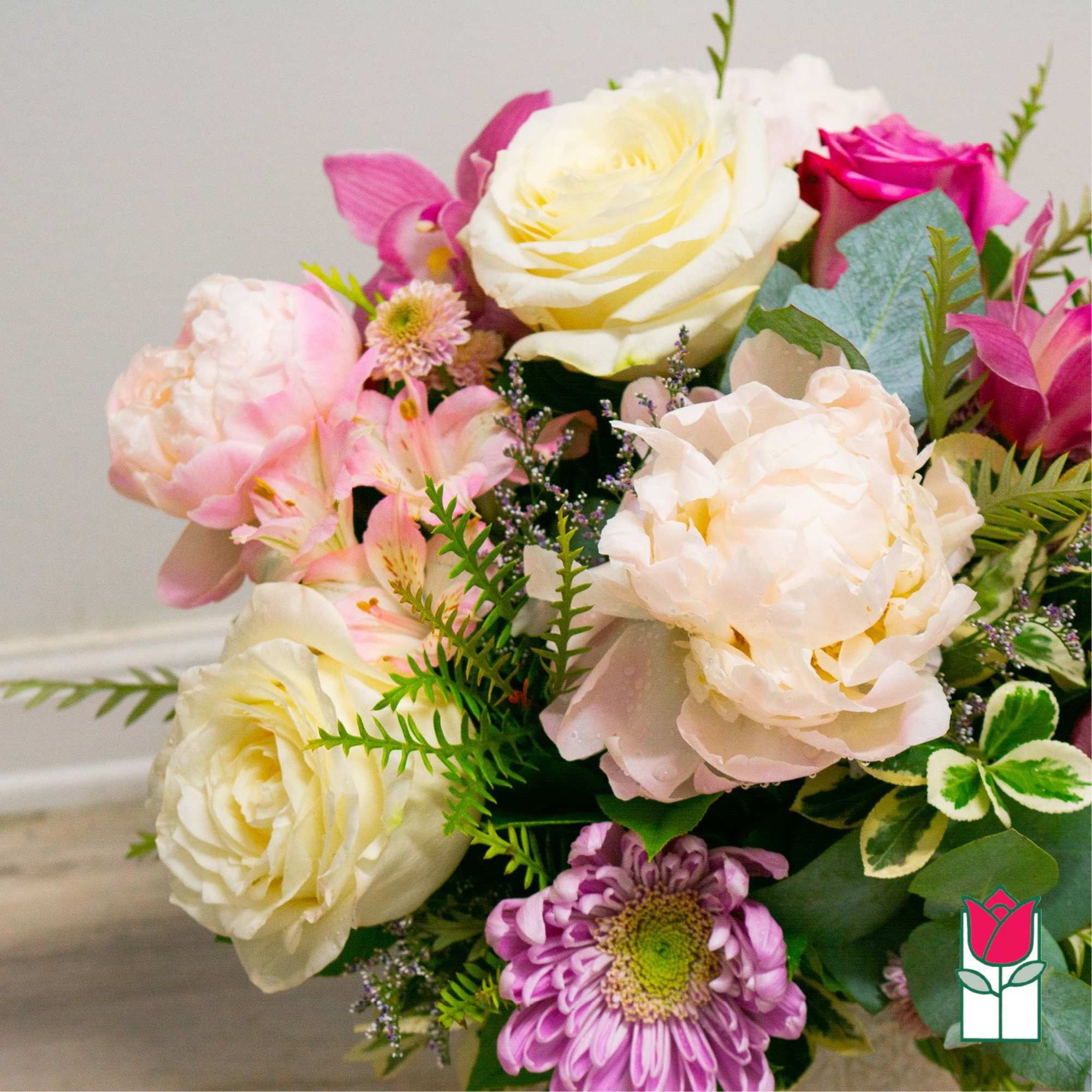Bouquet of pink, white, and peach flowers with mixed greenery