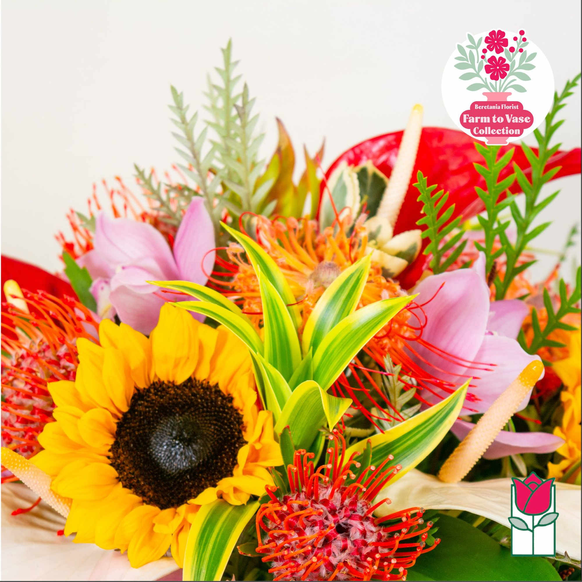 Bright mixed bouquet with a sunflower, pink blooms, and red tropical flowers