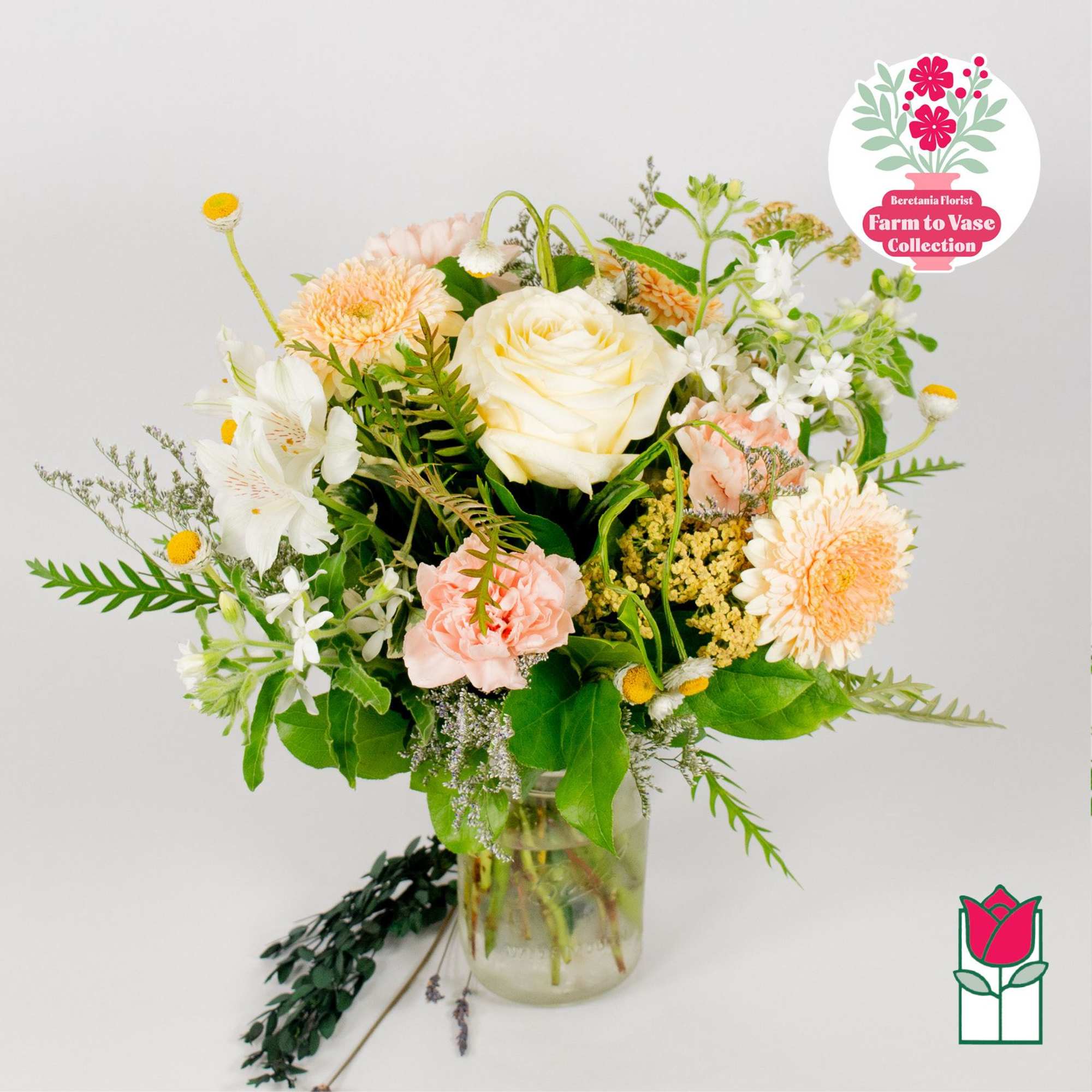 Mixed bouquet of roses, carnations, and daisies in a glass vase