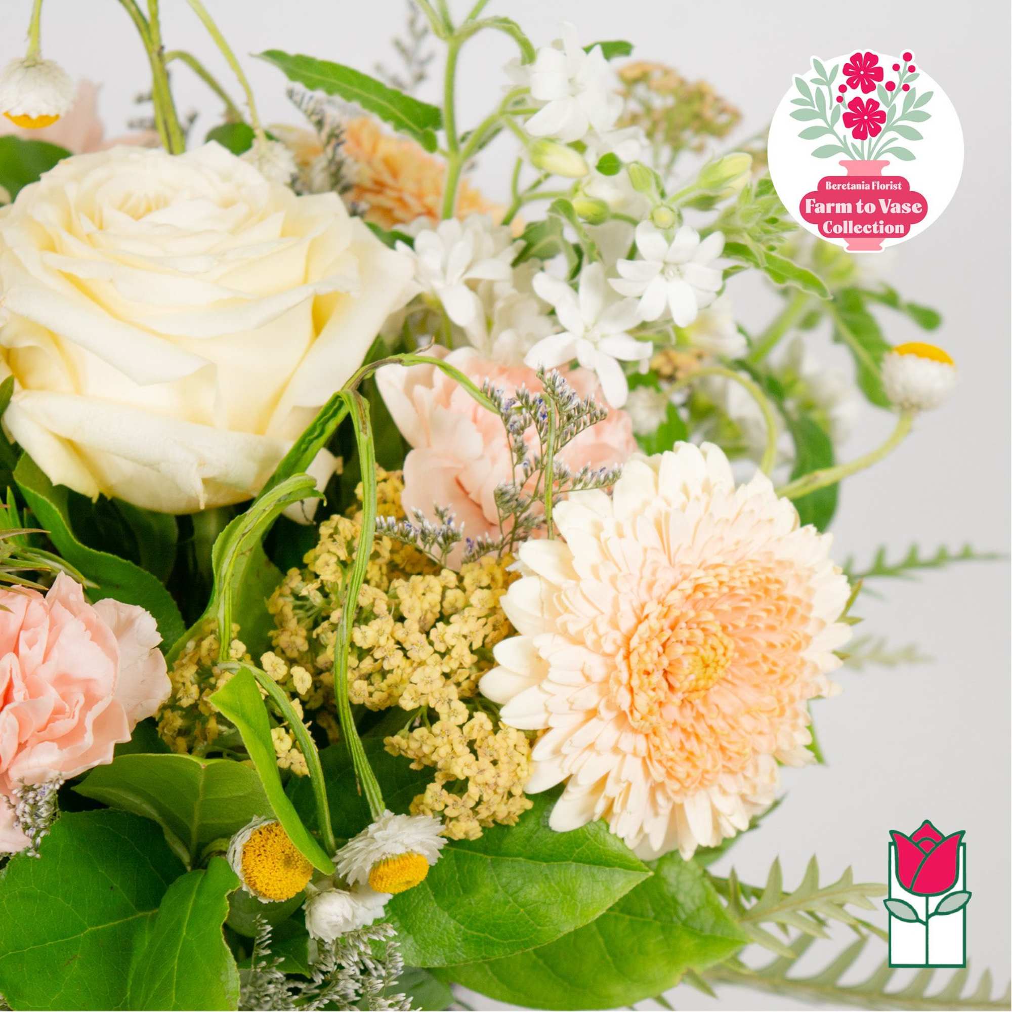 Bouquet of cream, peach, and white flowers with green foliage
