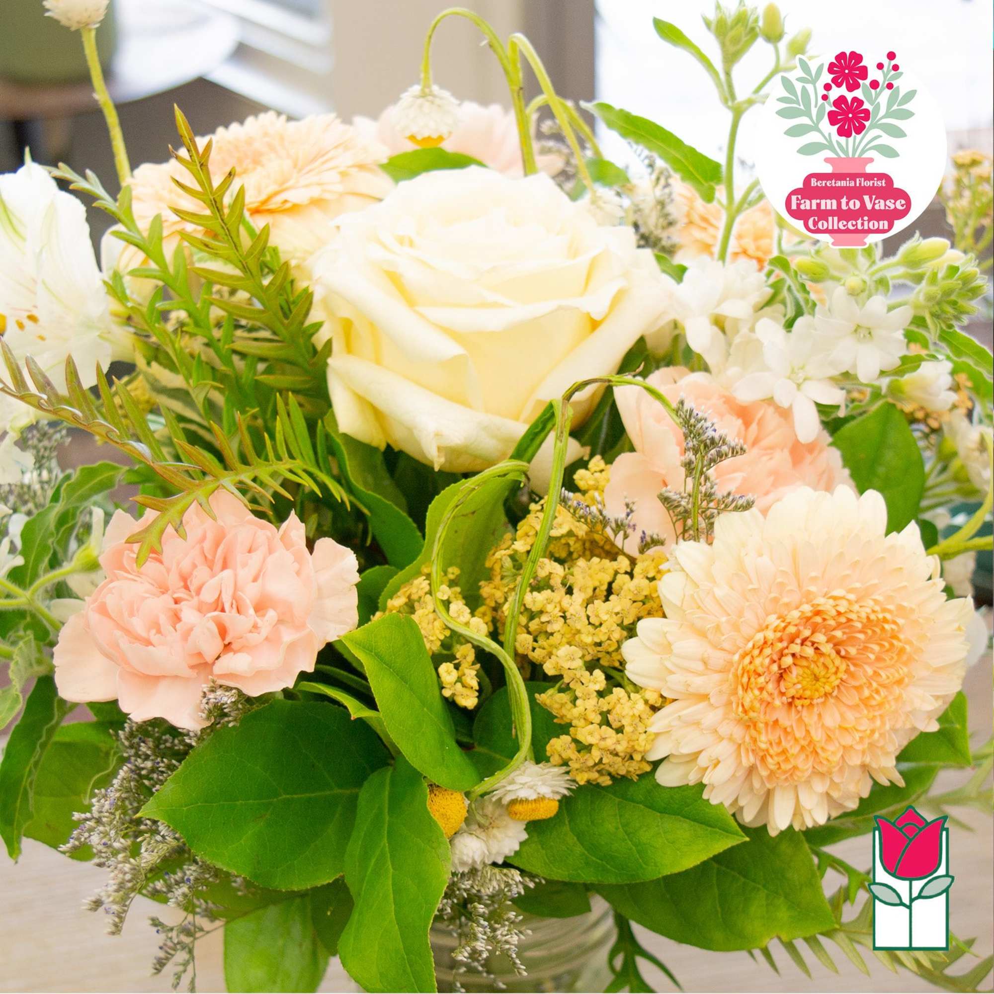 Cream and peach flowers arranged in a glass vase