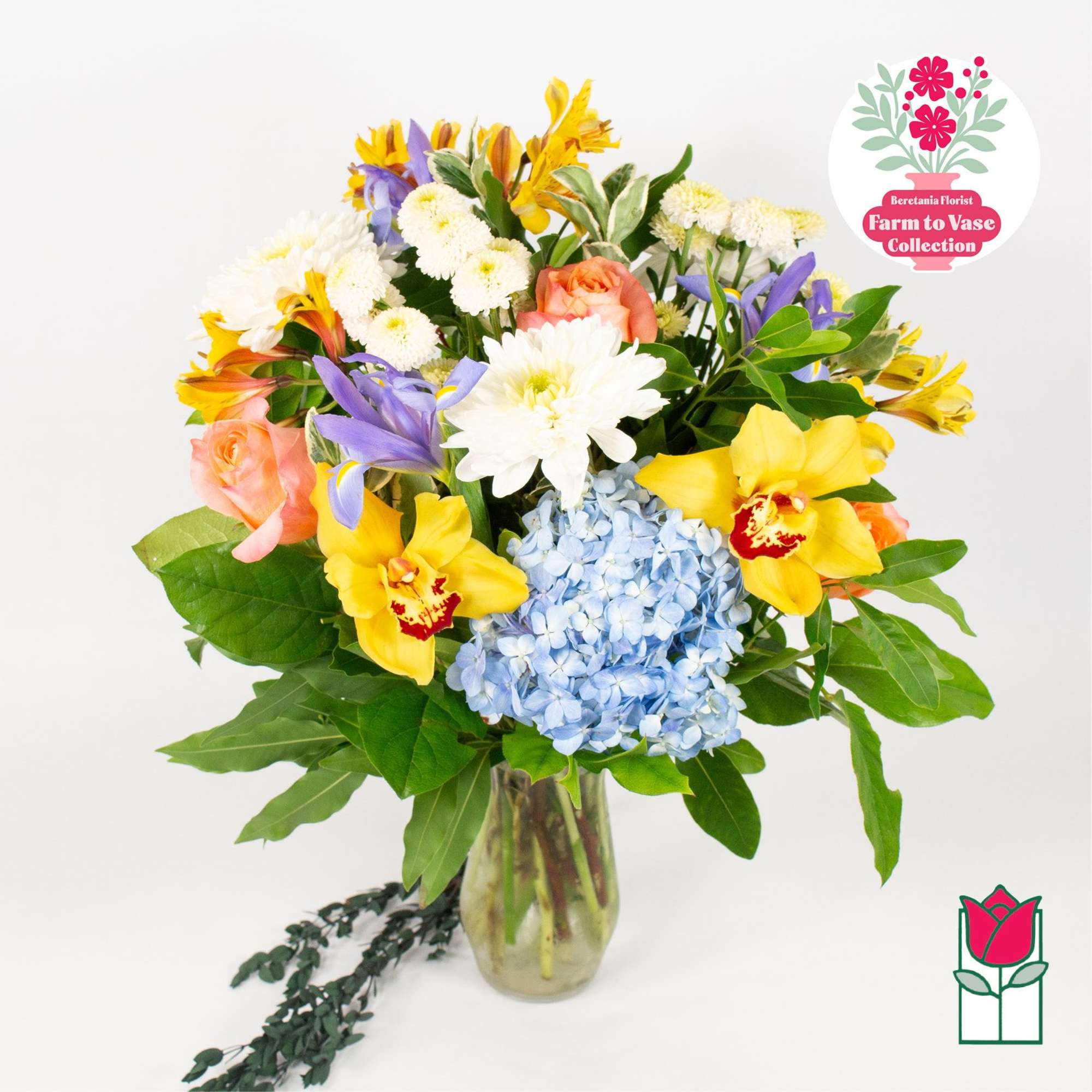 Mixed bouquet in a glass vase with blue hydrangea, yellow orchids, and pink roses