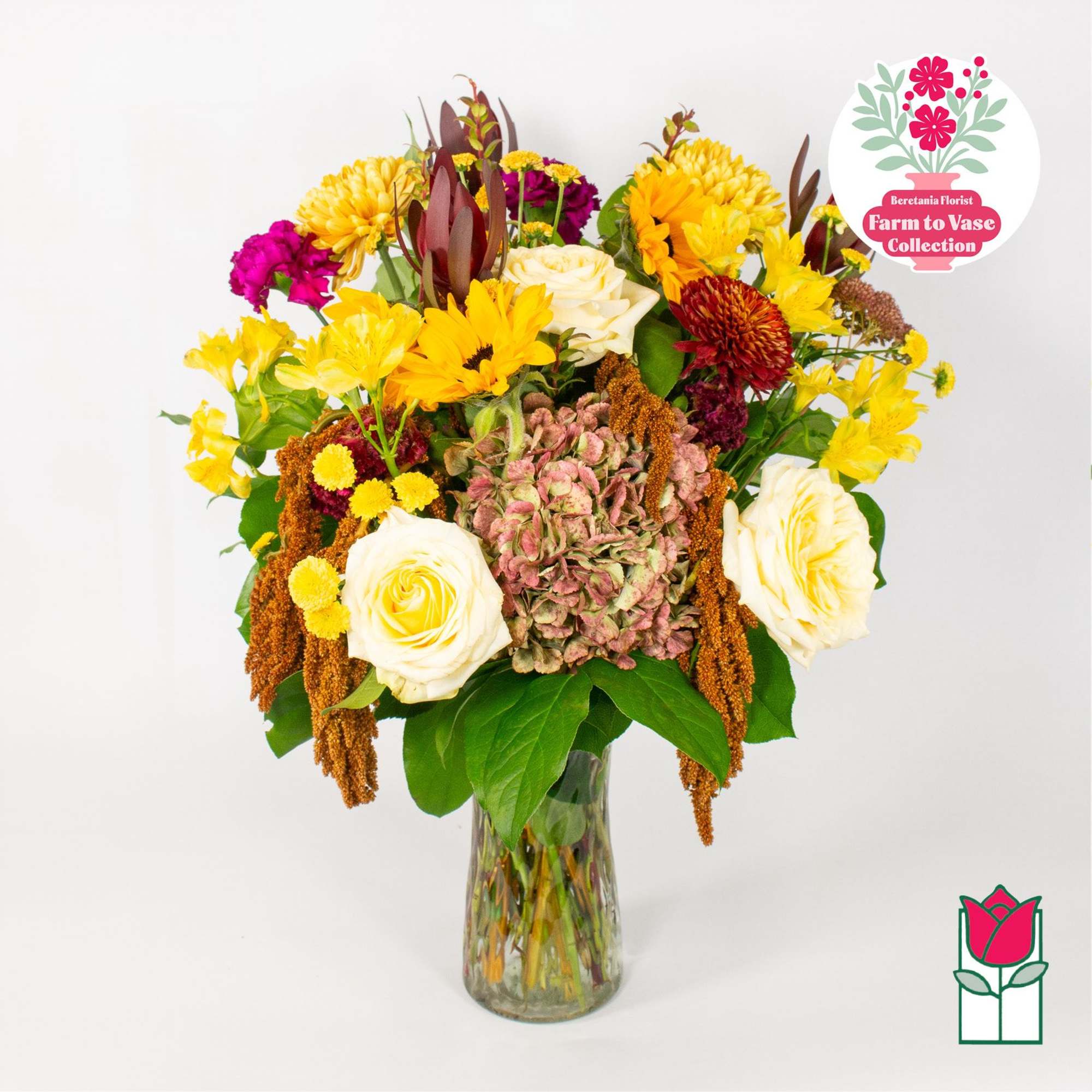 Mixed bouquet of yellow, white, and magenta flowers in a glass vase