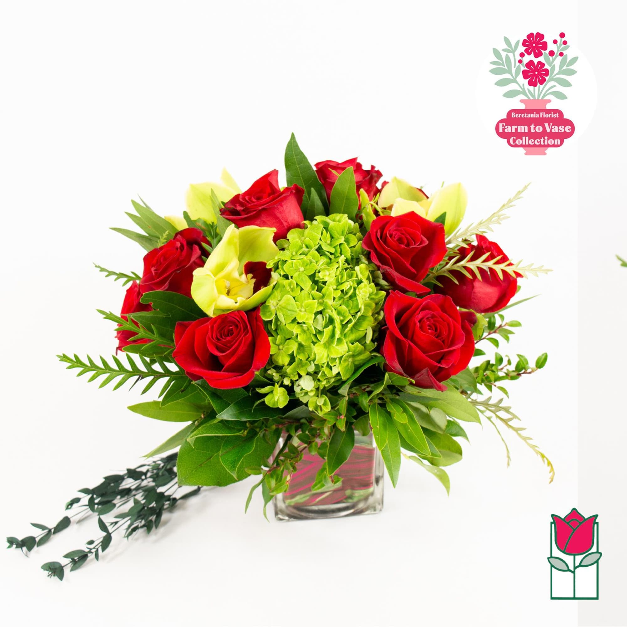 Red roses and yellow calla lilies in a glass vase