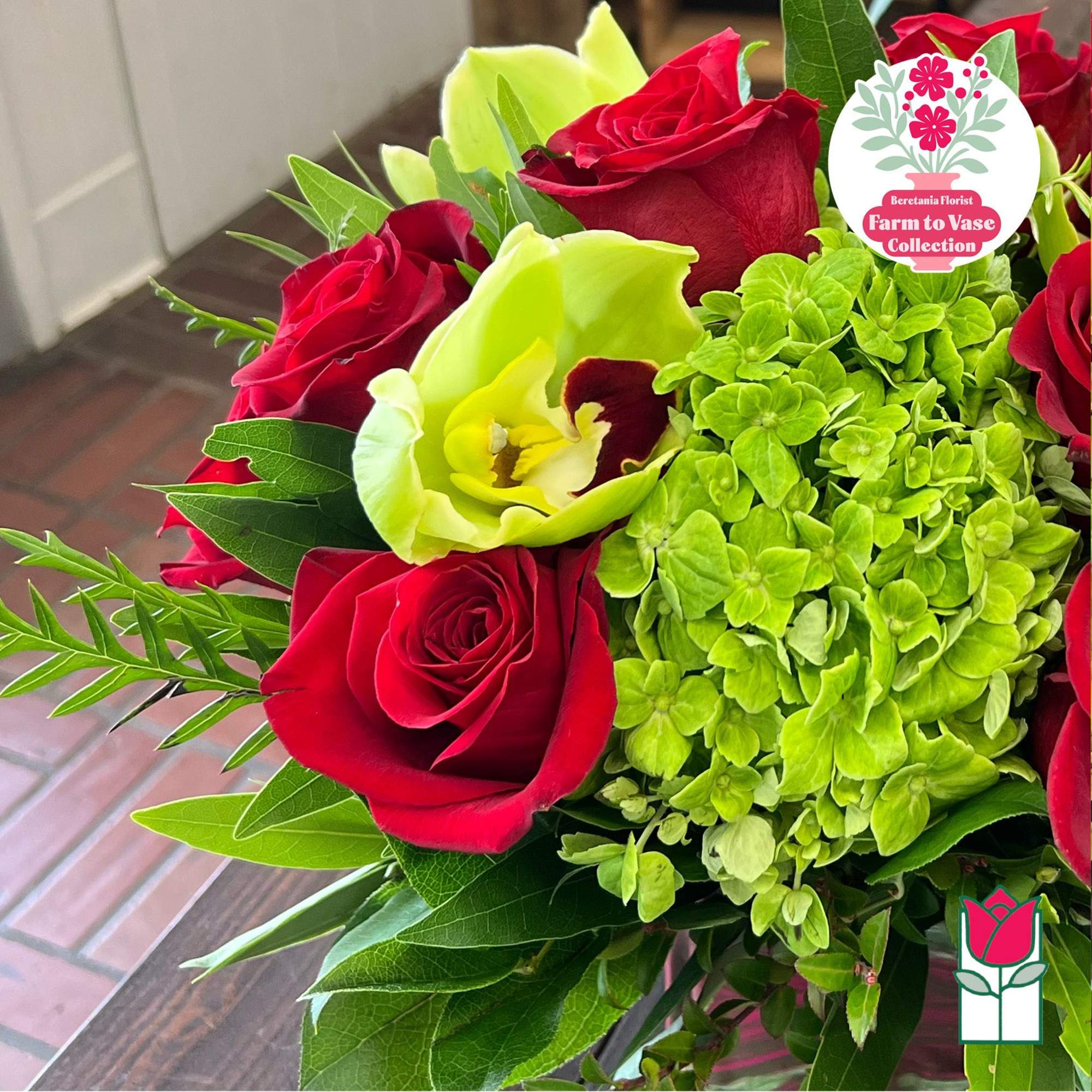 Red roses with a lime-green hydrangea bloom and a pale green calla lily