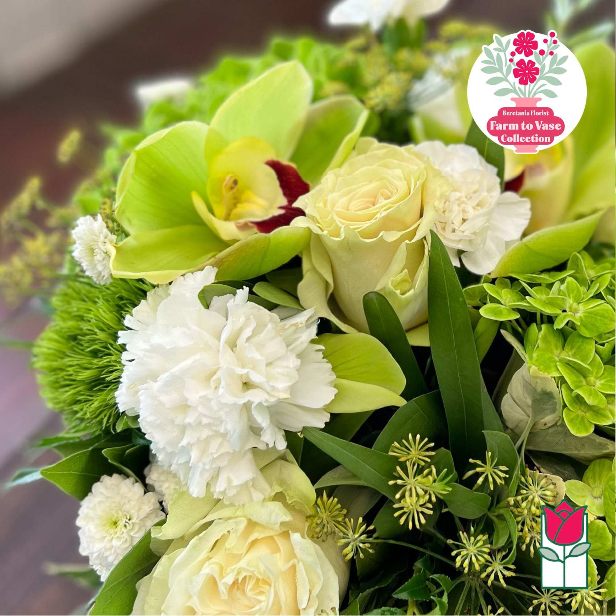 Cream roses and white orchids with green accents in a bouquet