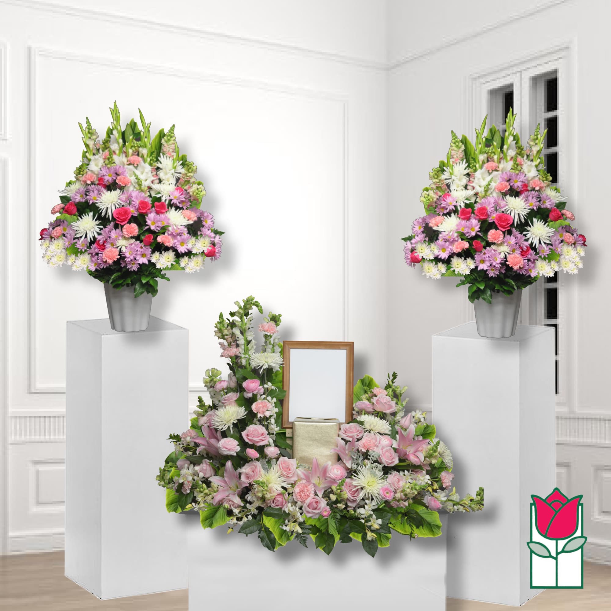 Three pink and white floral arrangements with a framed tribute display