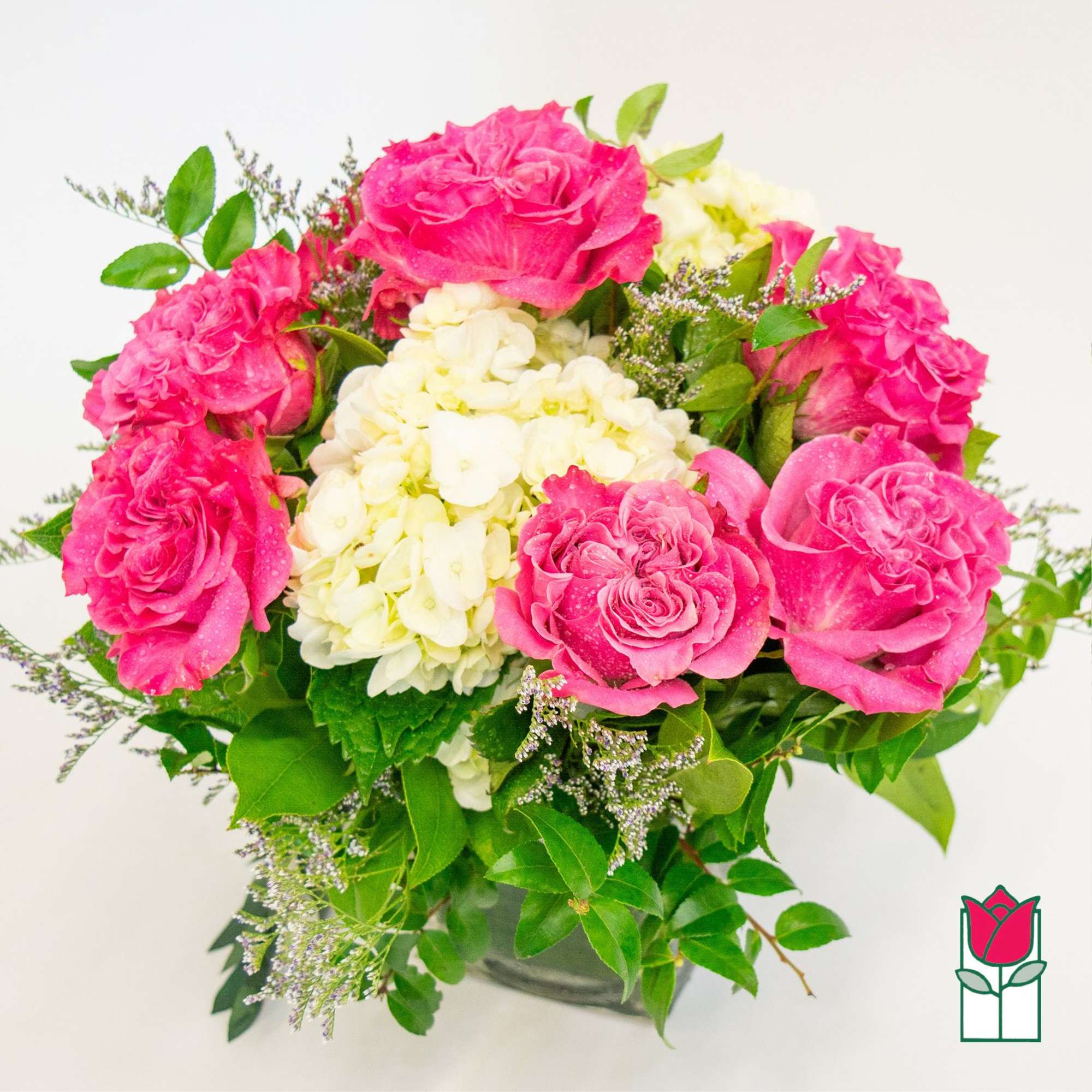 Pink roses and white hydrangea in a low vase arrangement